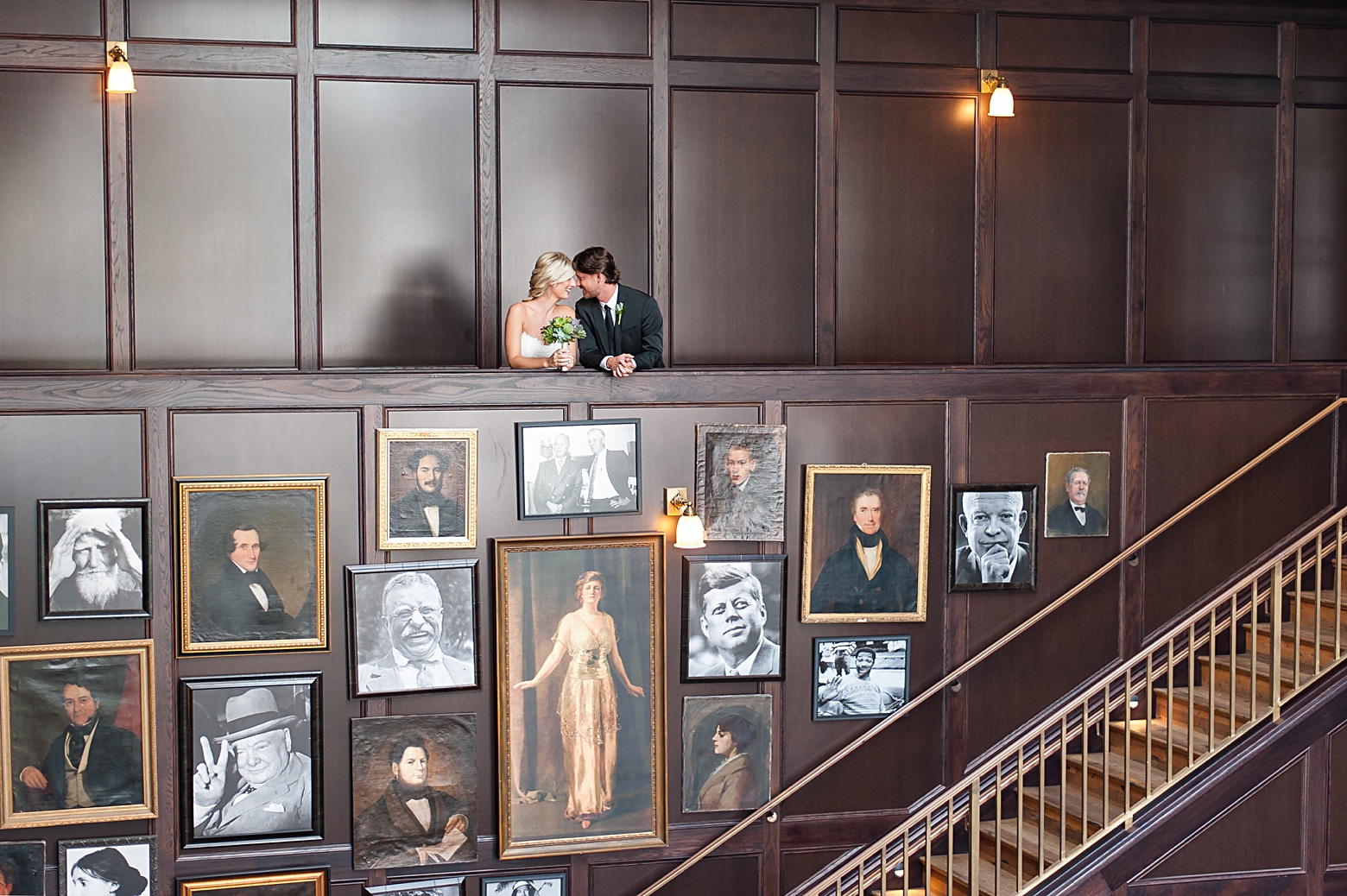 Bride and Groom above the portrait wall inside the Oxford Exchange for their wedding