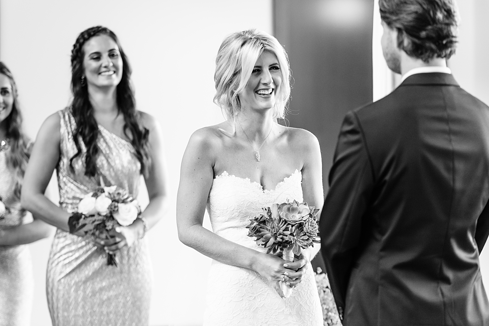 Bride laughs during the Grooms vows in classic black and white