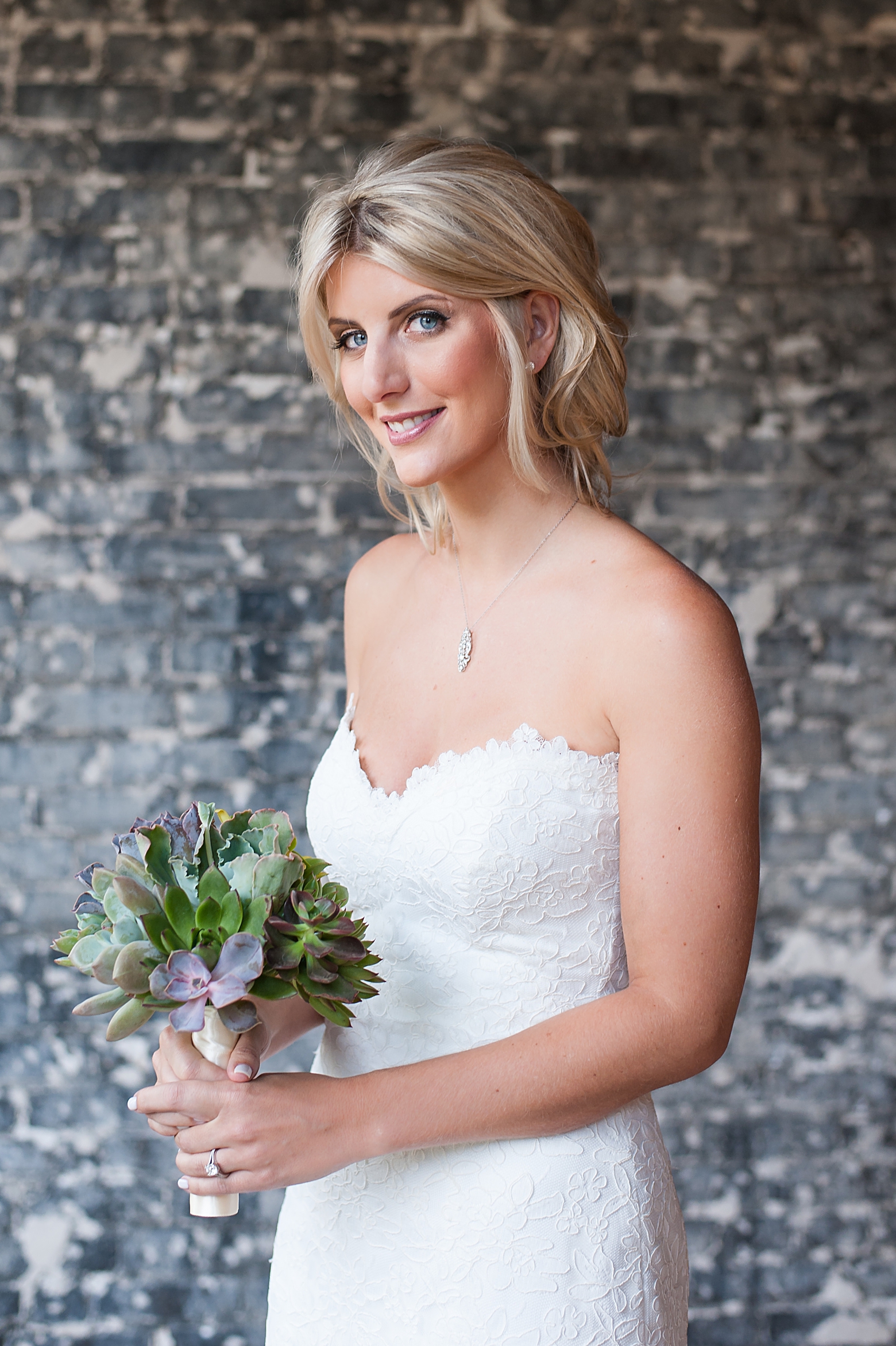 Bride holding her succulent filled wedding bouquet by Sarah and Ben Photography