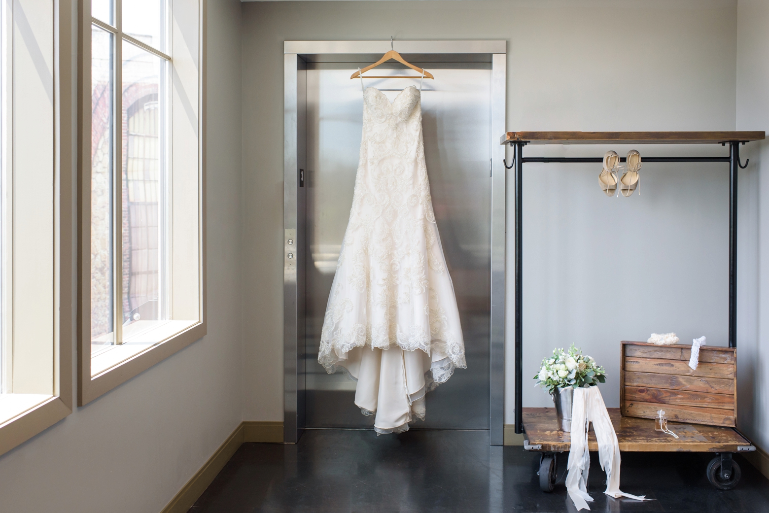 The wedding dress hanging in front of an elevator door at the epicurean hotel