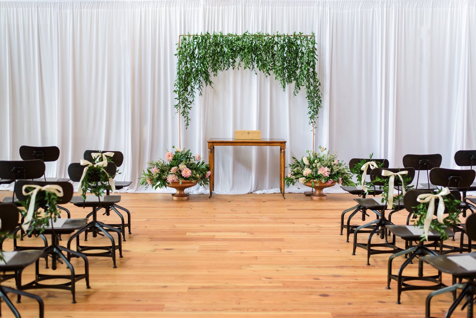 The ceremony space with a greenery arch in Oxford Exchange's library