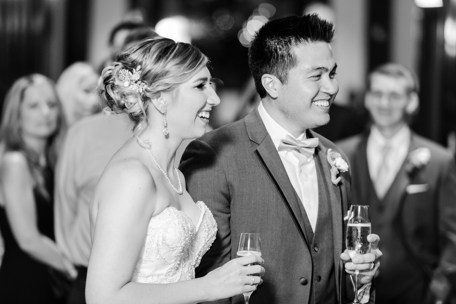 Bride and Groom smile as they listen to speeches during their wedding reception