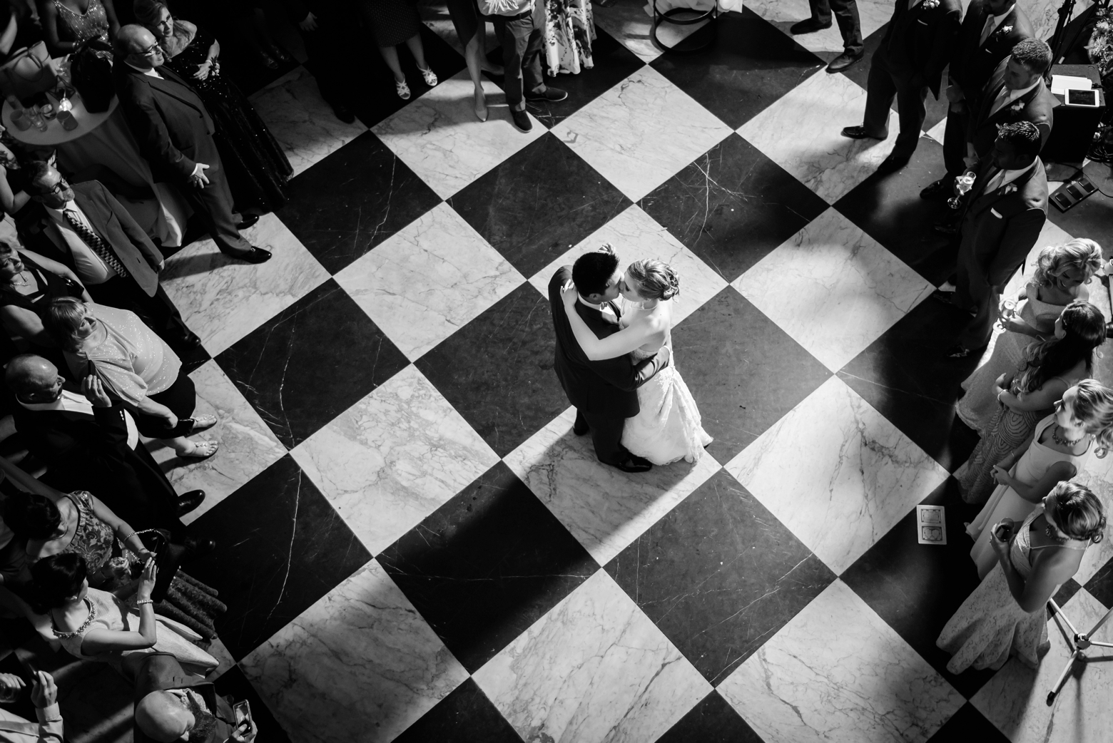 Bride and Groom dance their first dance on the checkerboard tile lobby inside the Oxford Exchange