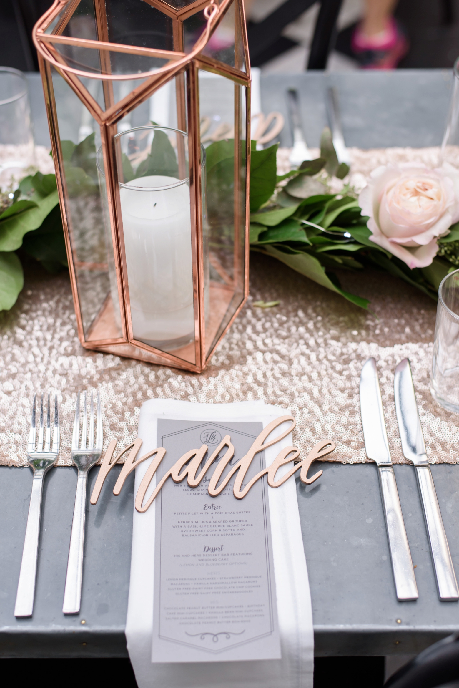 Custom name place holders and rose gold candle holders fill the table during reception
