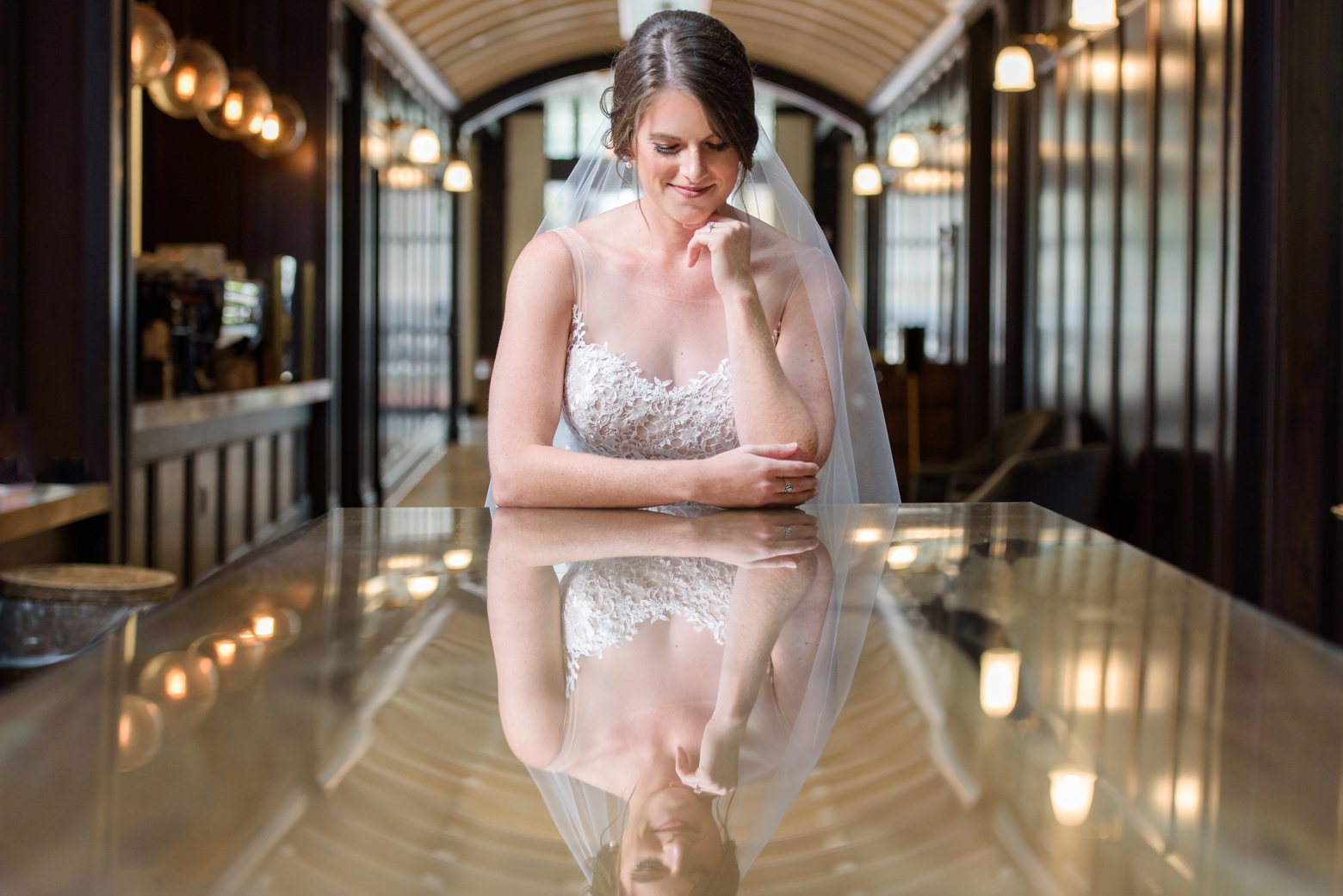 A bride stands in the foyer looking at her reflection at her Oxford Exchange bridal session