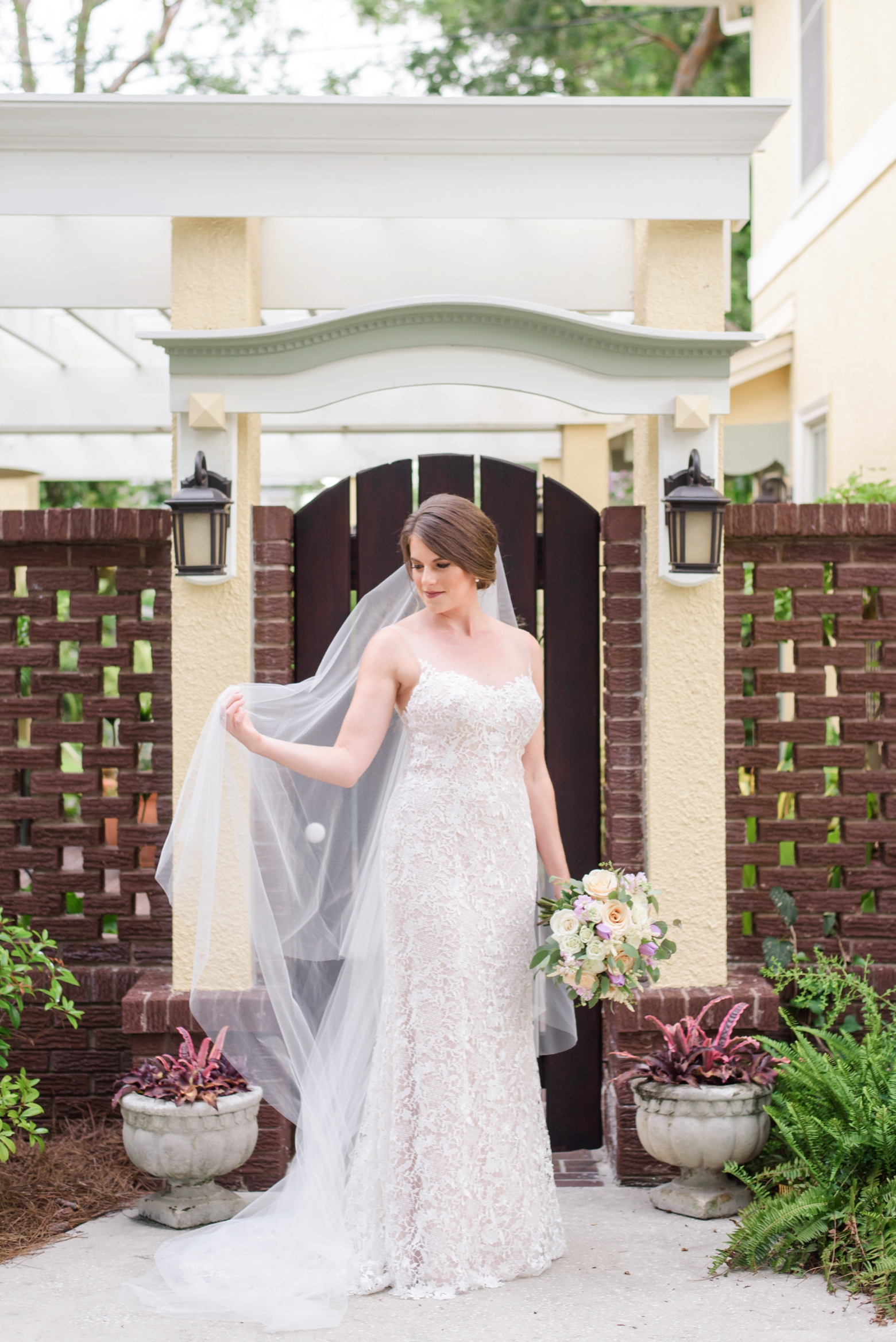 Bride holds her cathedral length veil during her Tampa bridal session at home