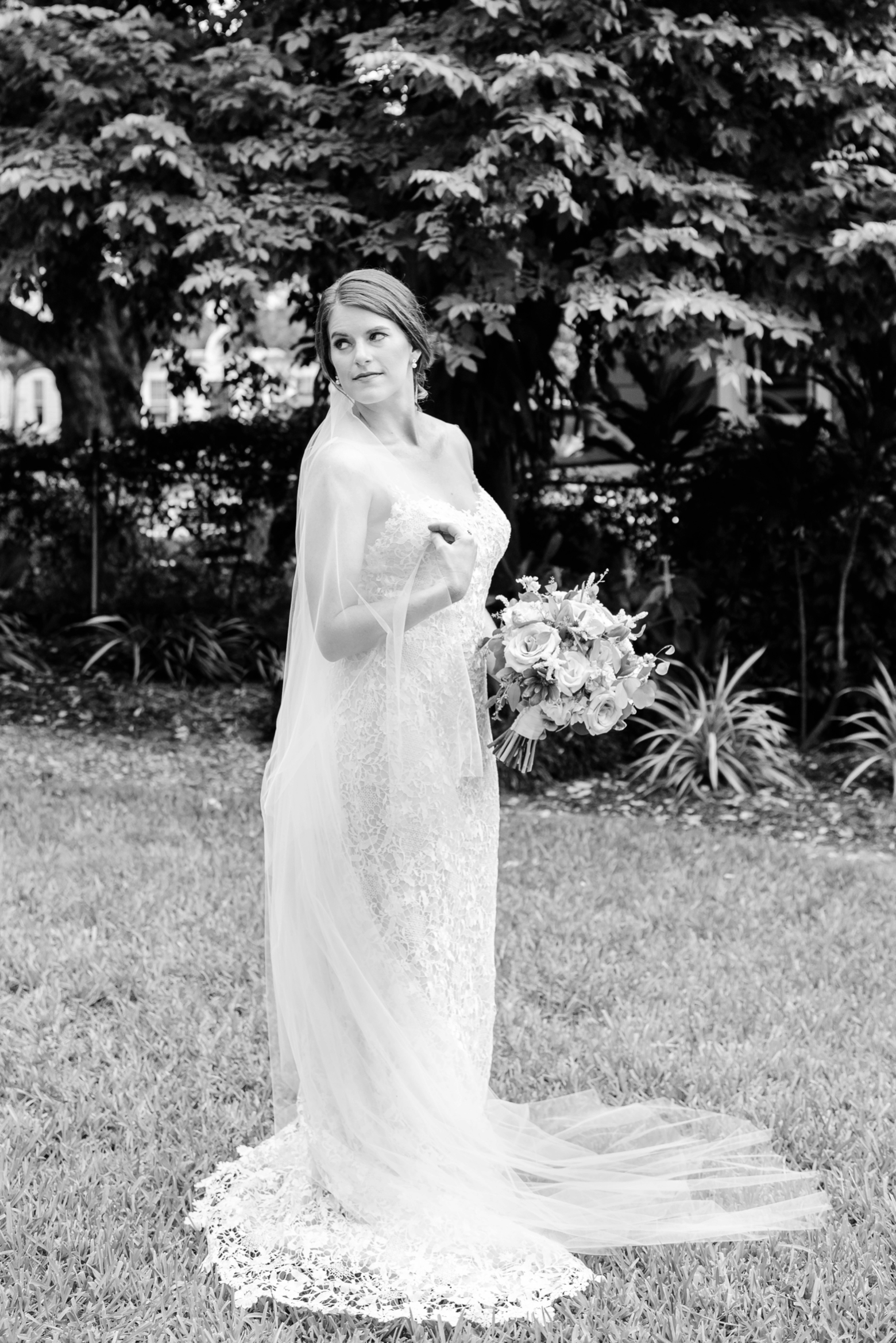 Bride wraps herself up in her cathedral veil during her bridal session outside her Tampa home
