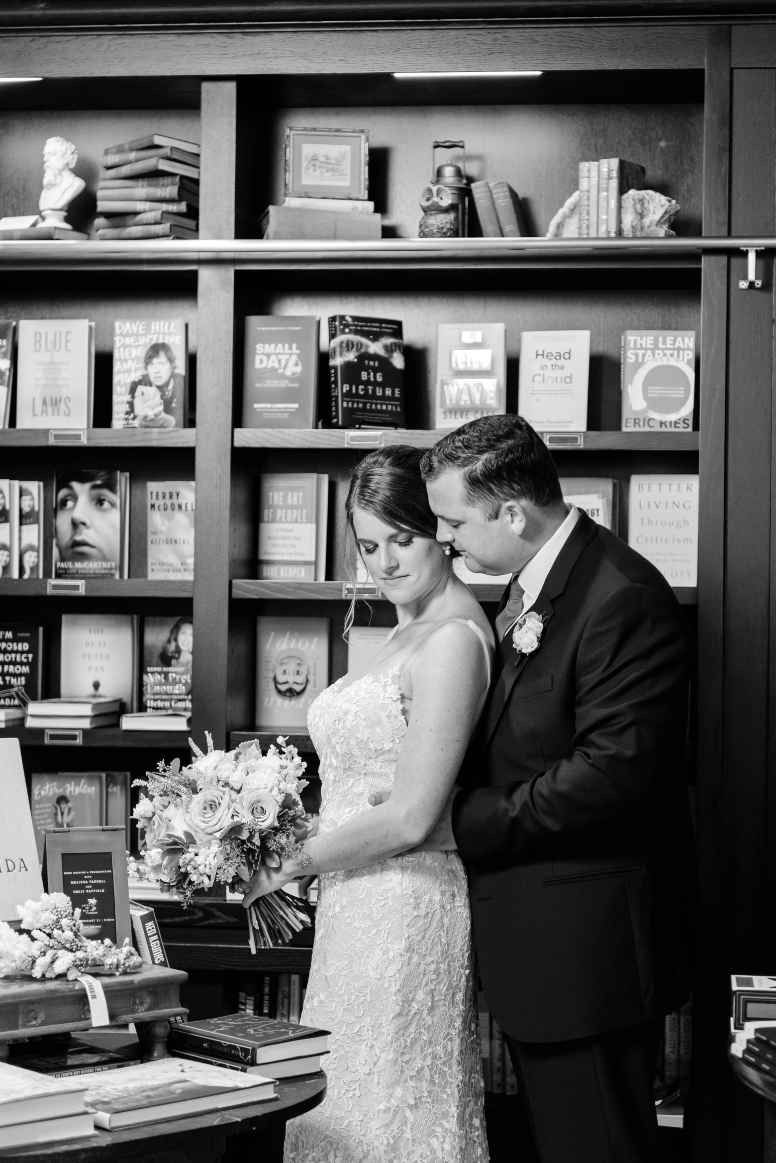 black and white photograph of a bride and groom standing in the bookshop during an oxford exchange wedding reception