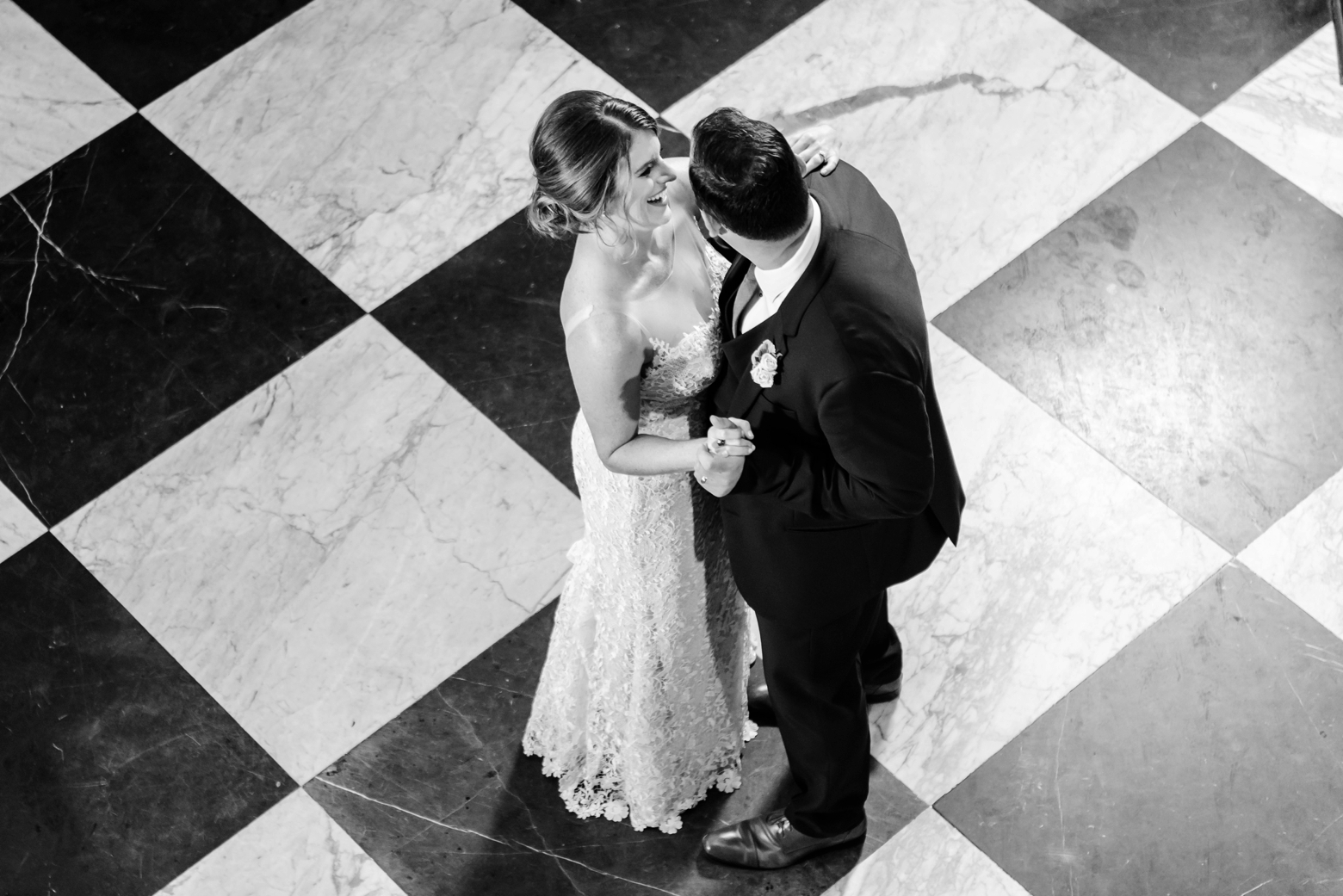 Tampa Wedding Photograph above a bride and groom dancing in the oxford exchange wedding reception's checkerboard tile floor