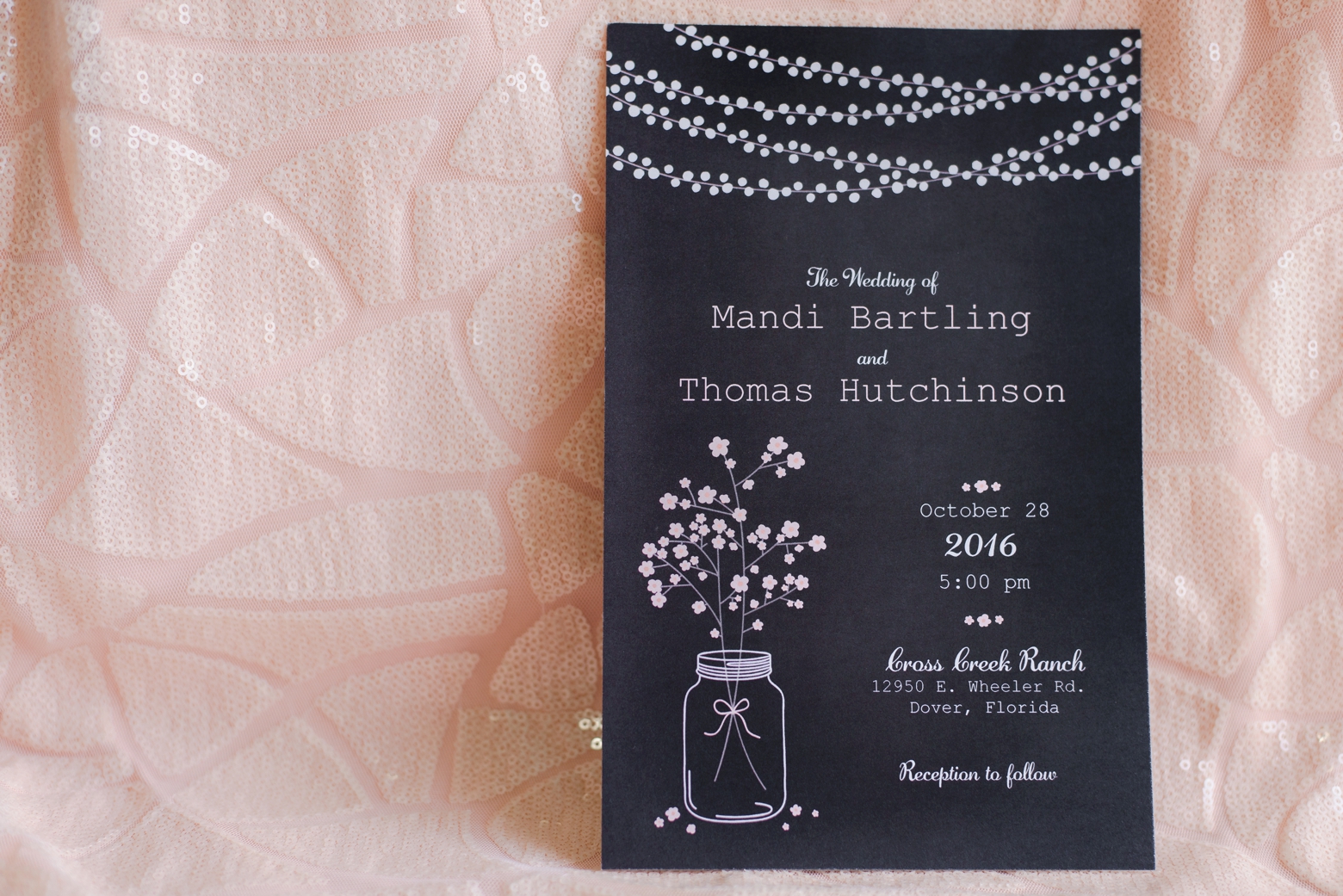 Wedding invitation against a soft pink background by Sarah & Ben Photography