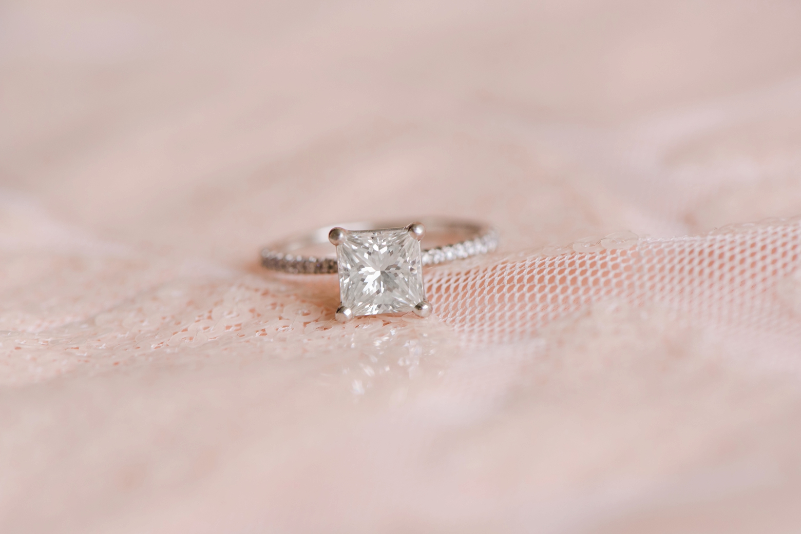 The Bride's engagement ring sits atop a blush tulle