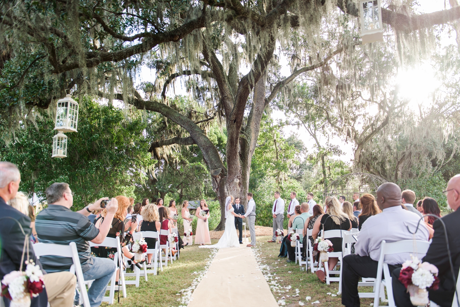 Wide shot of a Cross Creek Ranch wedding day from the back of the aisle under the old oak tree
