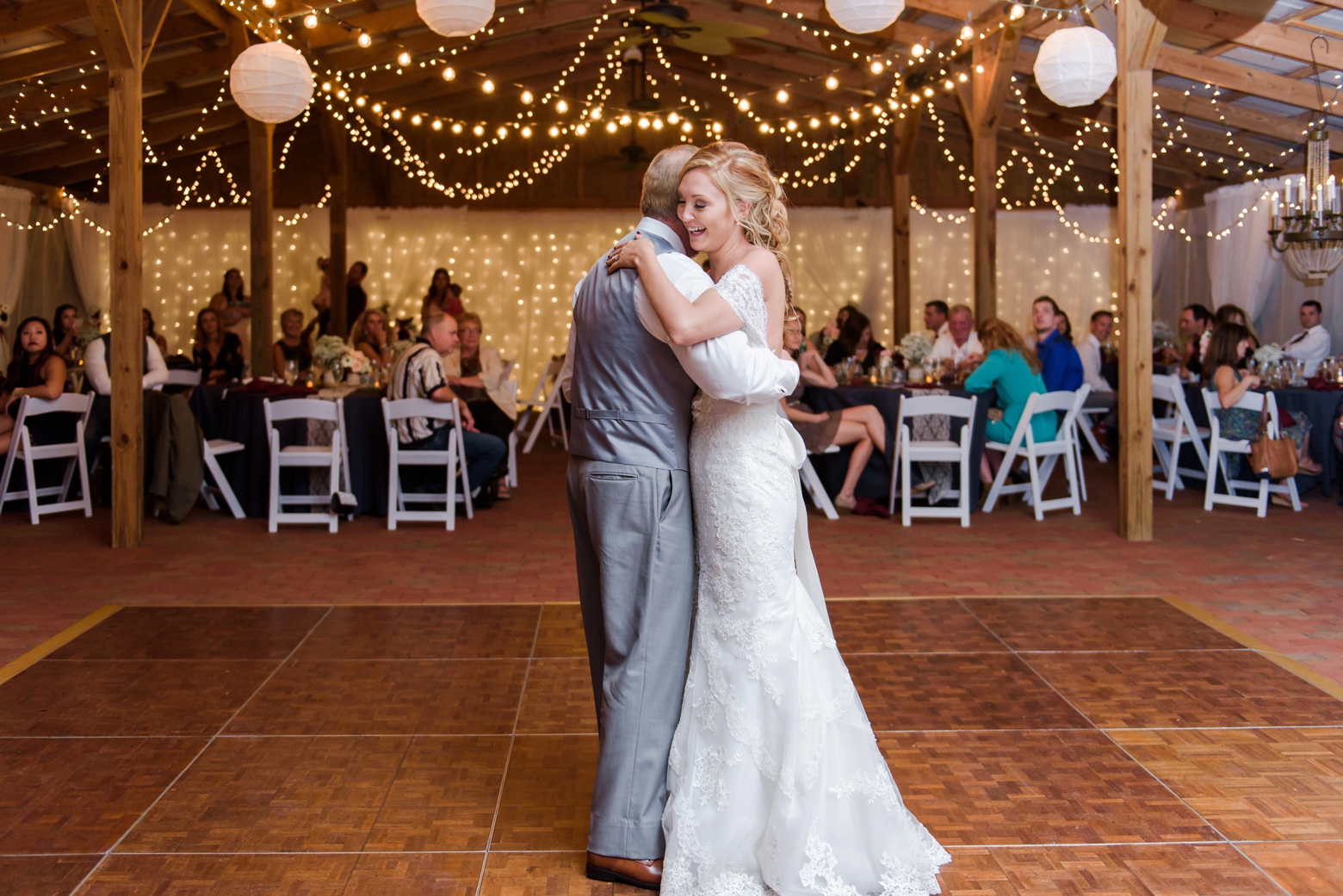 The father daughter dance under the twinkle lights in the barn at Cross Creek Ranch