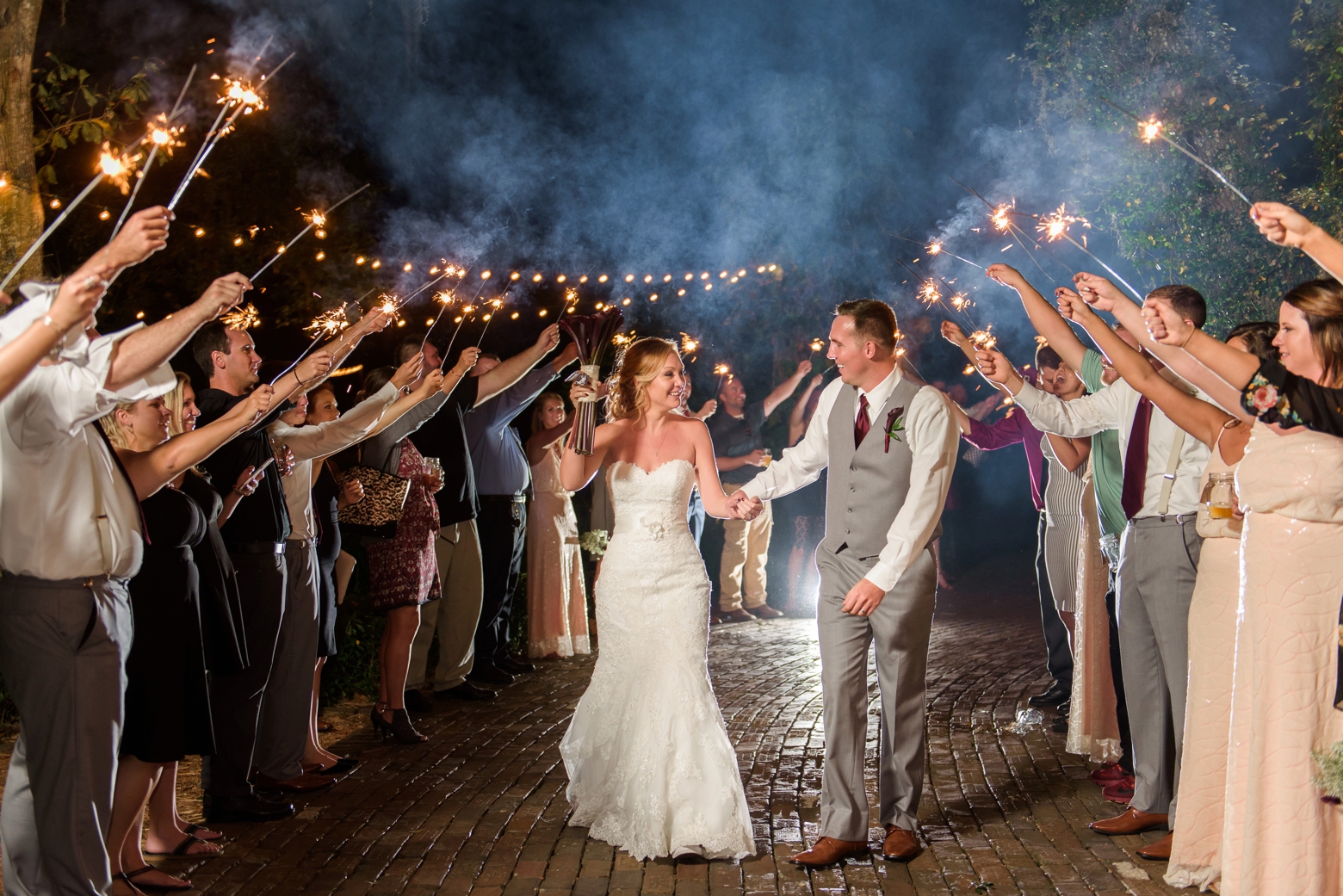 Bride and Groom exit their Cross Creek Ranch wedding day under a line of Sparklers held by friends and family