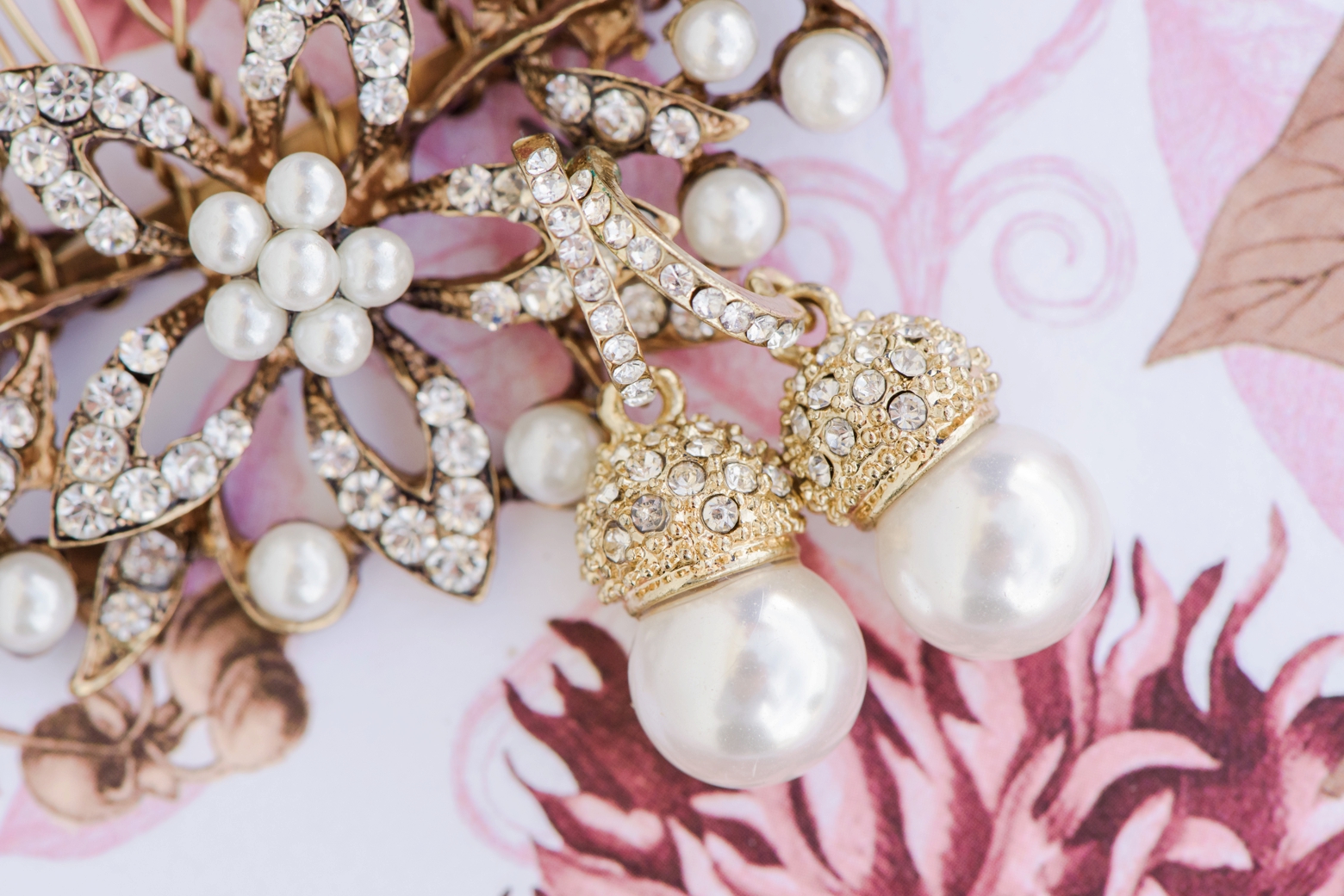 Close-up detail of the Bridal jewellery against a floral background by Sarah and Ben Photography