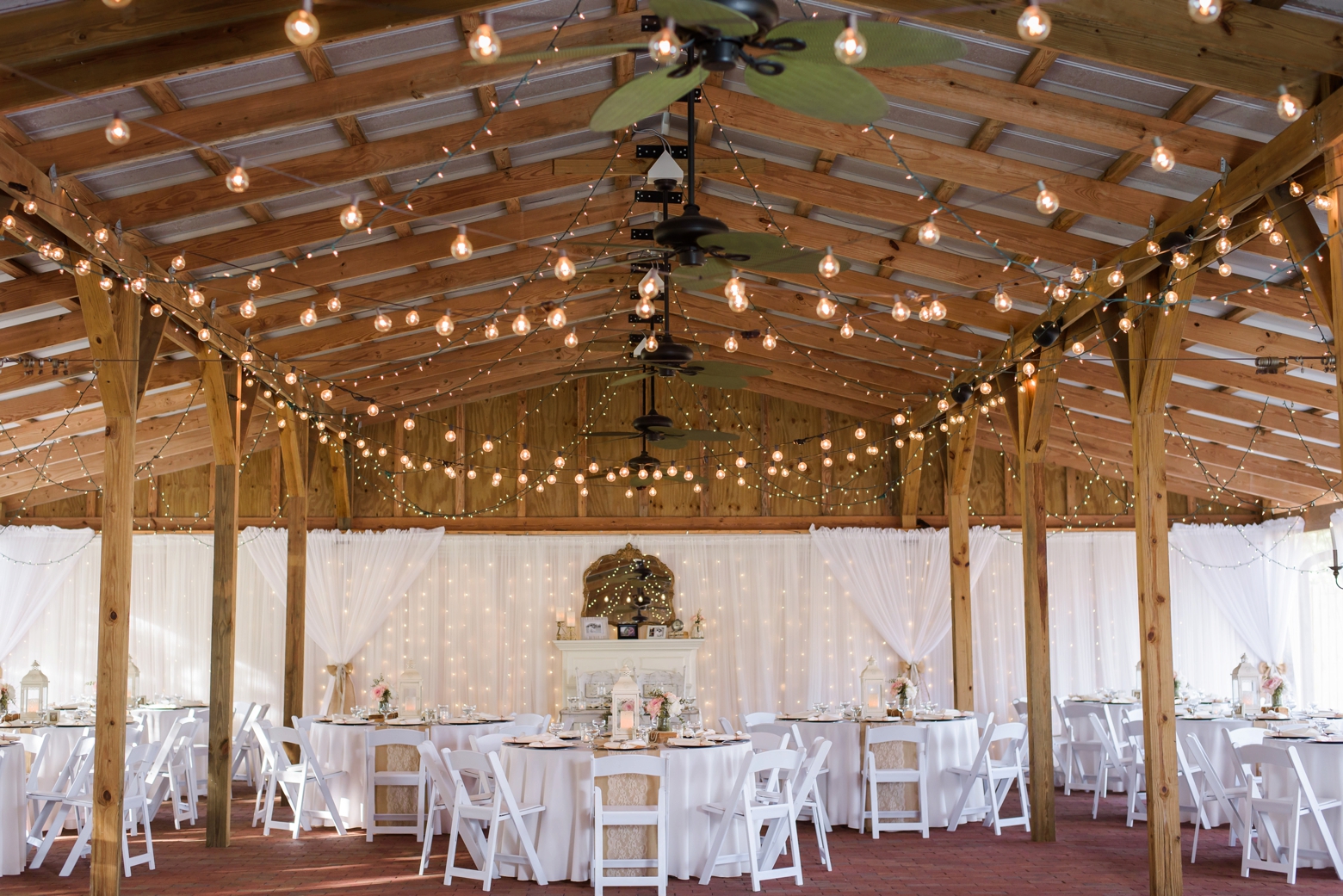 Wedding reception venue decorated in twinkle lights and white tulle