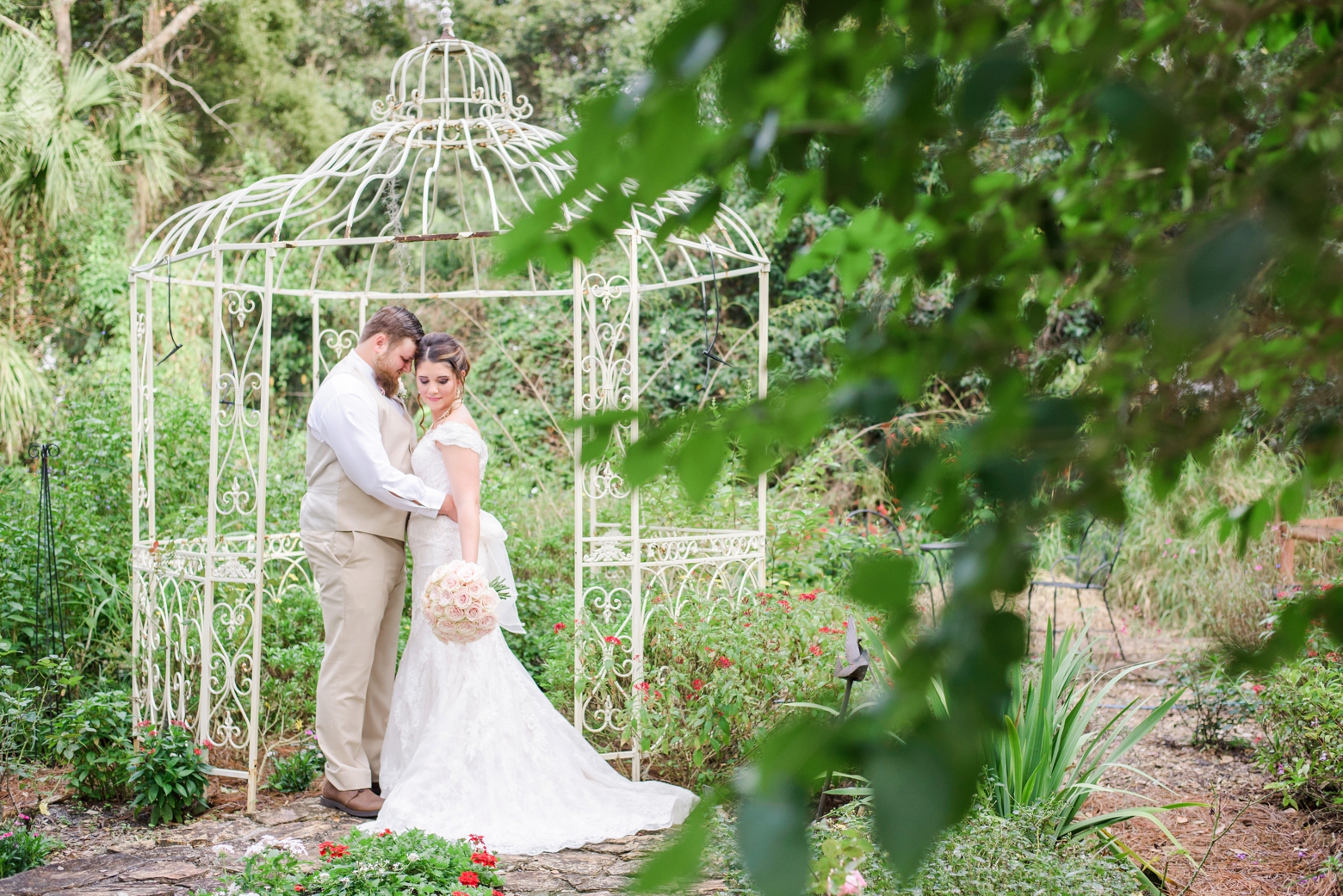 Bride and Groom snuggle up for a quiet moment in the gardens before their wedding ceremony