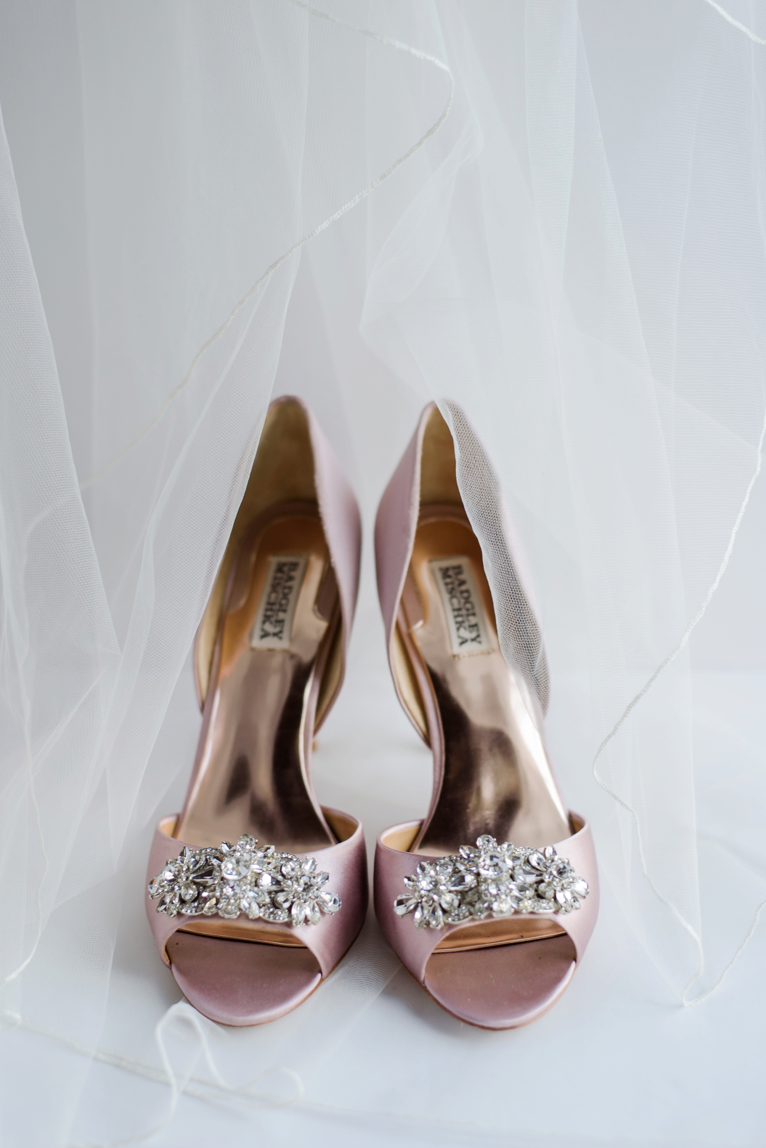 Bridal shoes with diamond accents sitting on the wedding veil tulle