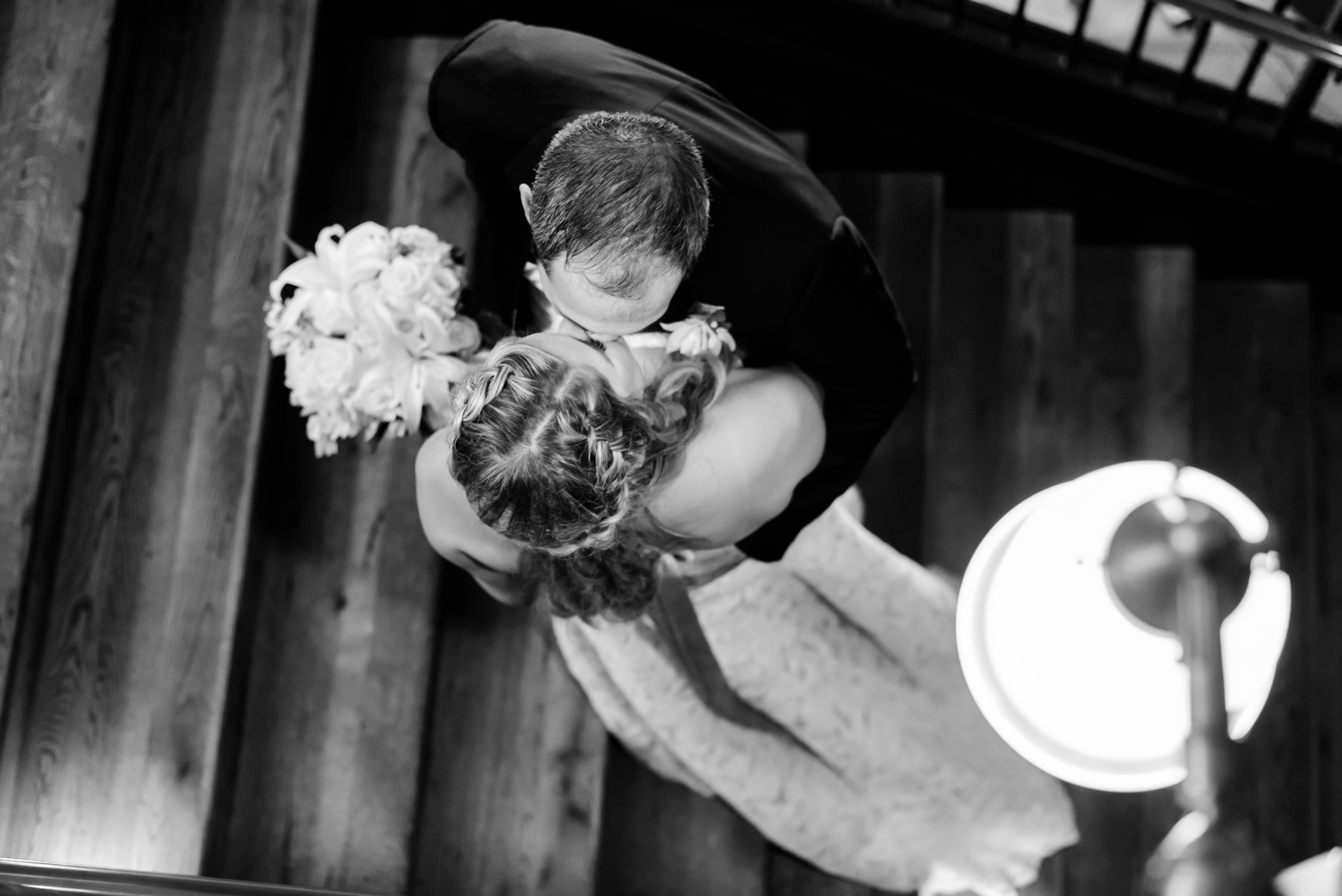 Birdseye view of a Bride and Groom sharing a kiss on a staircase in Oxford Exchange