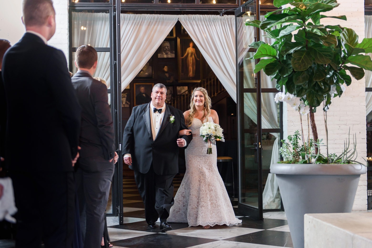 Bride and her Dad enter her oxford exchange wedding day through some glass doors