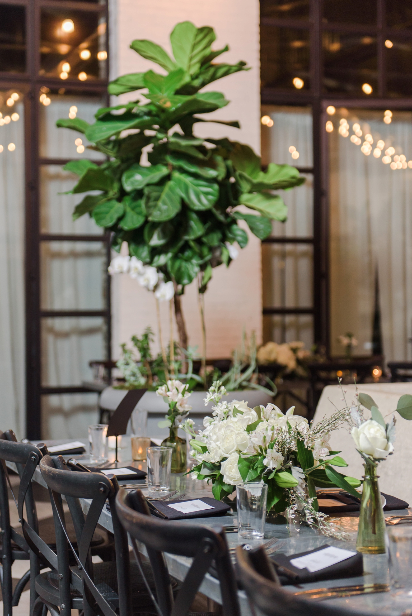Wedding reception with small floral centerpieces and string lights