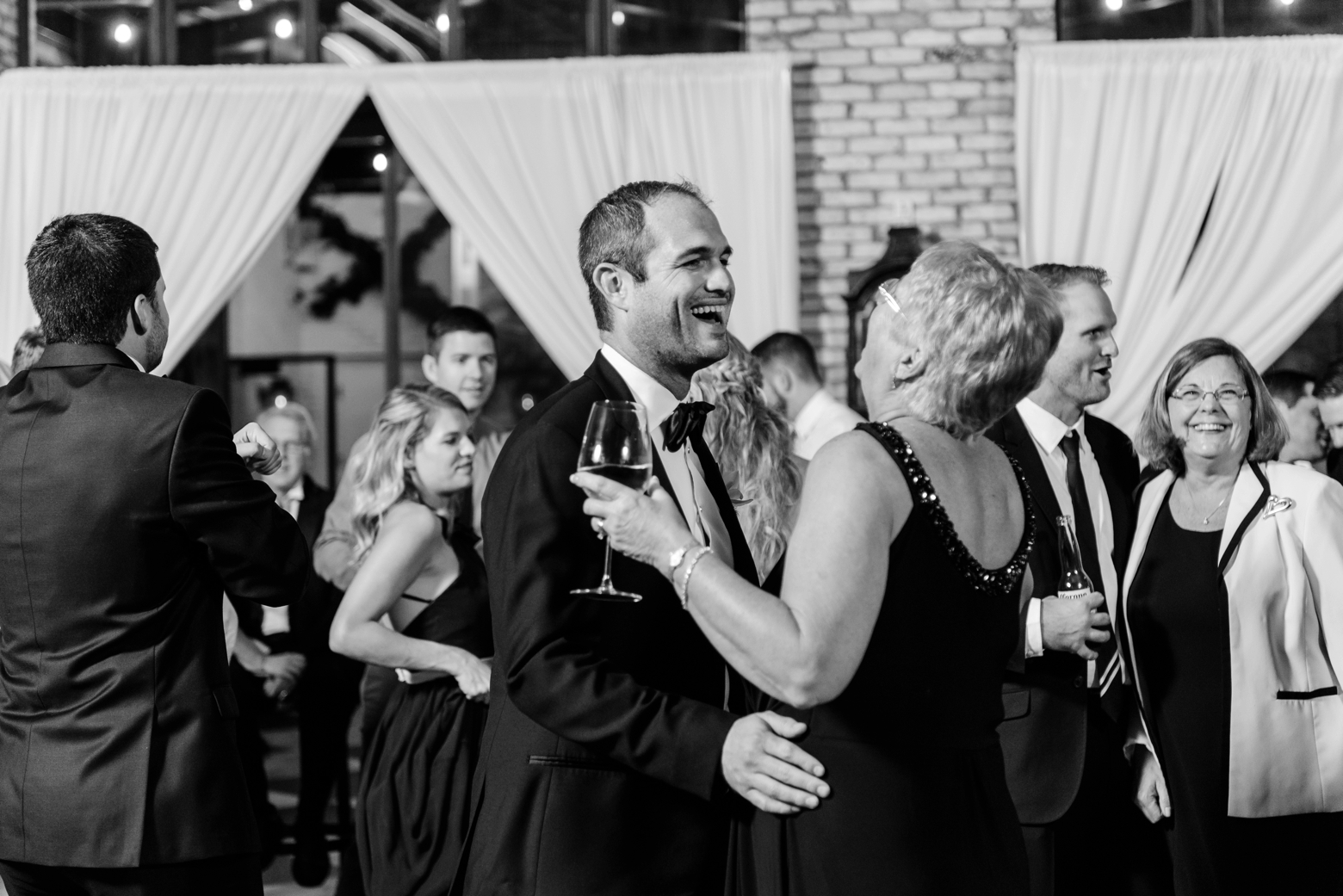 Groom laughs with a wedding guest during the dance party at their oxford exchange wedding 