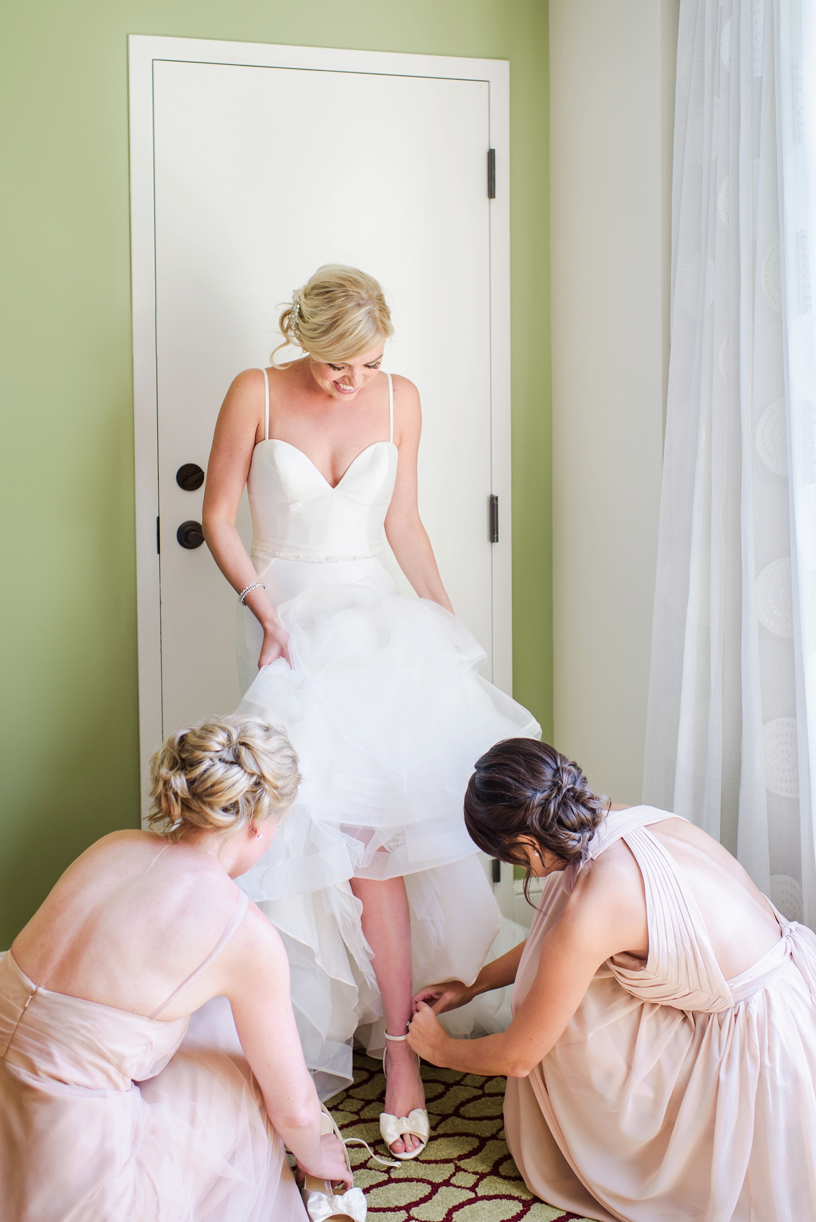 Bridesmaids help the bride with her Kate Spade shoes
