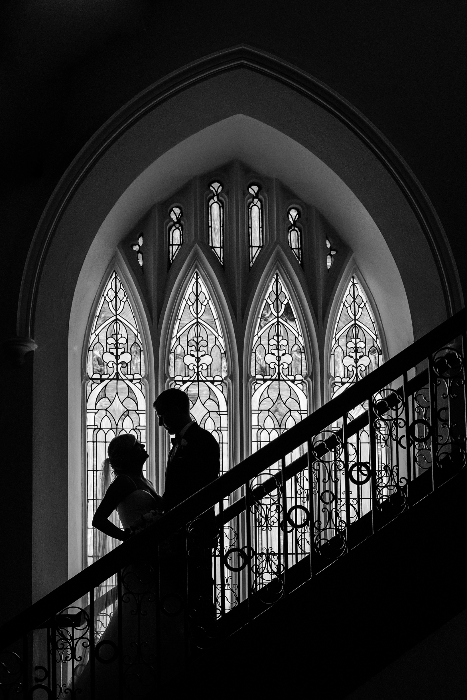 Black and White Silhouette of the bride and Groom with a stained glass window by Sarah & Ben Photography
