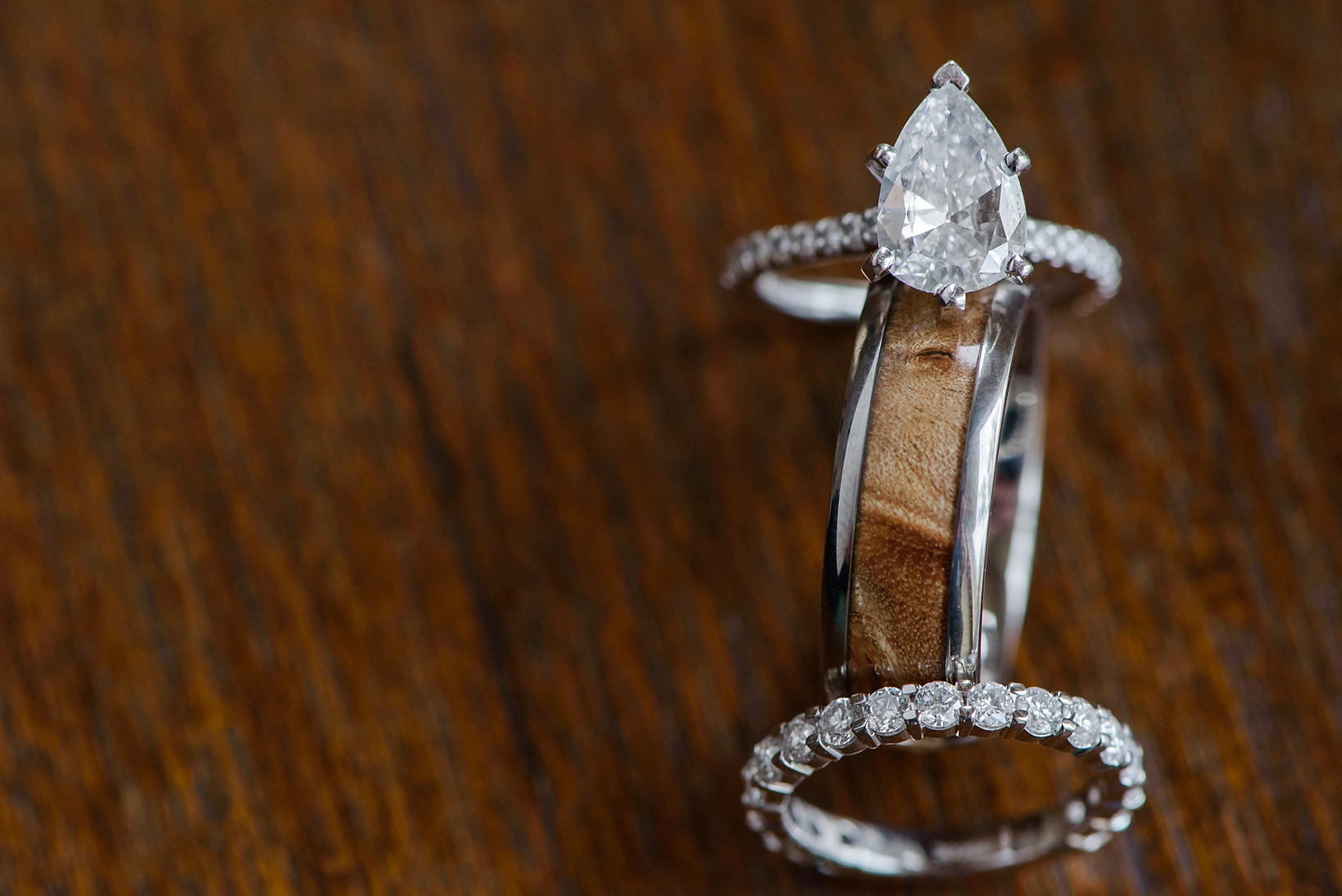 The wedding rings against a wood grain background