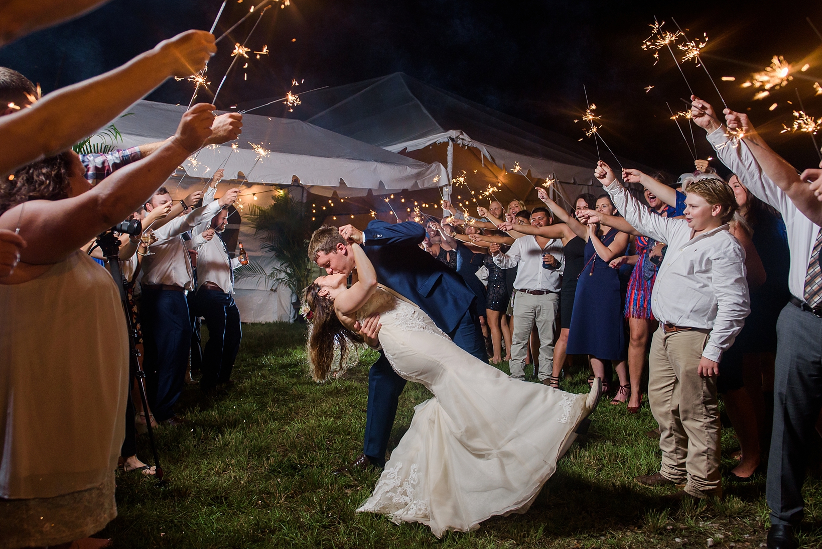 Bride and Groom share a dip kiss under the sparklers of their guests 