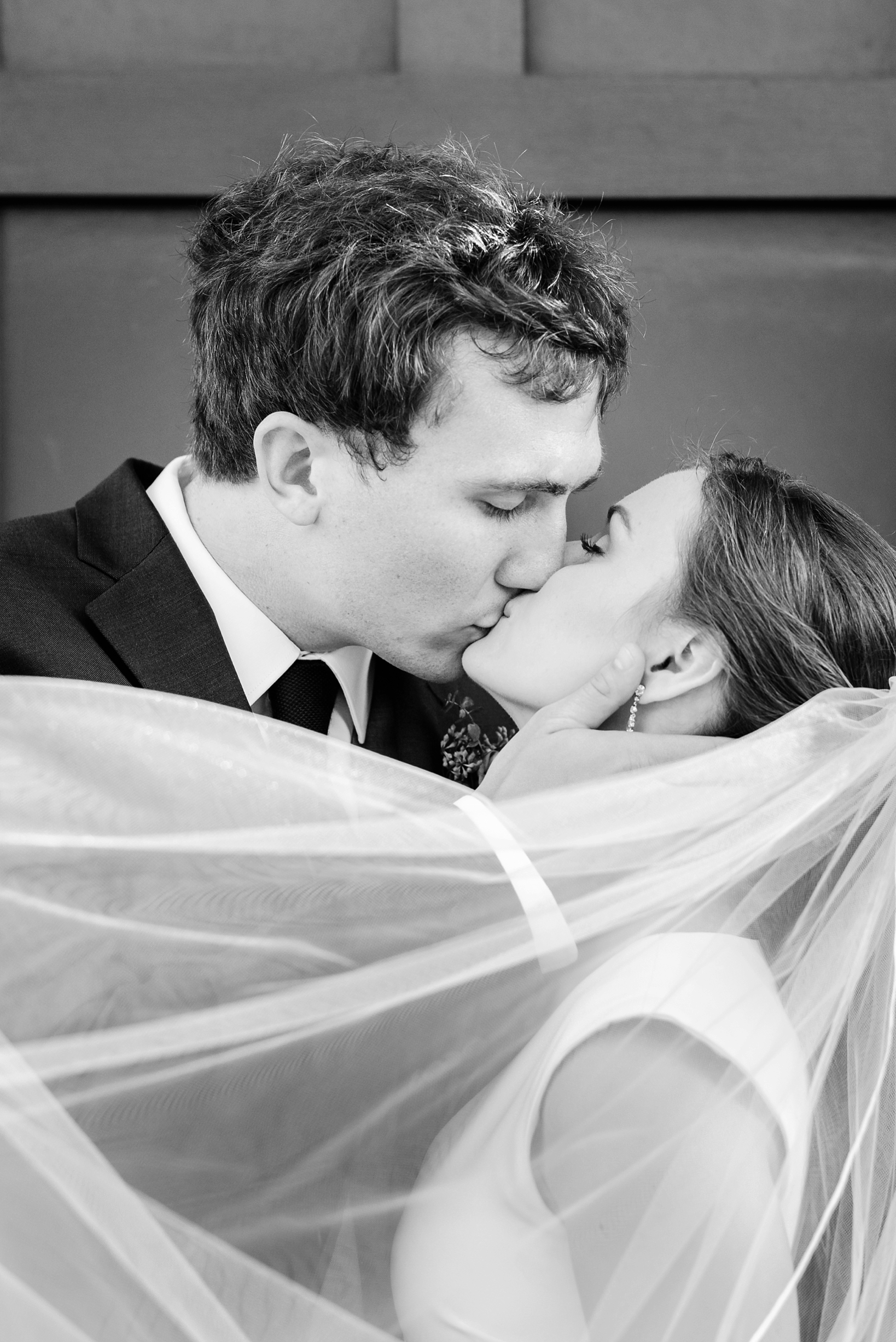 A close-up photo of a kissing couple on their wedding day