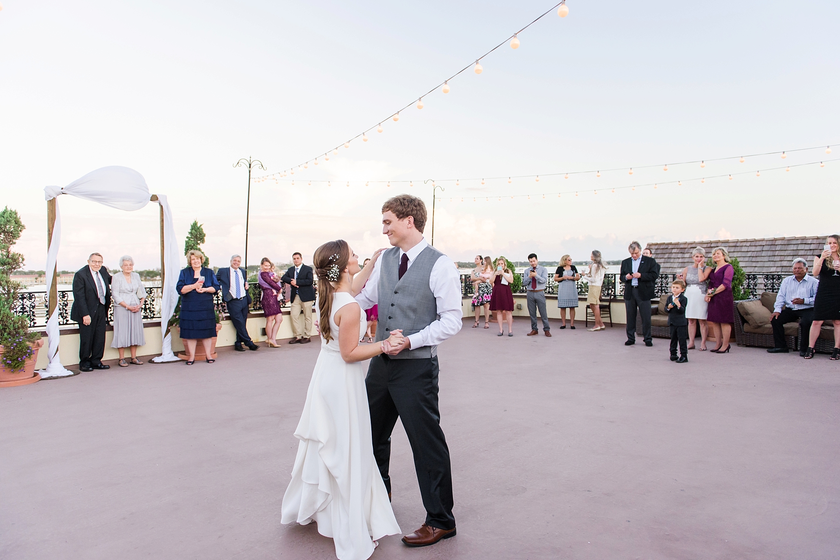 First dance with all their friends and family surrounding them on the open air rooftop deck