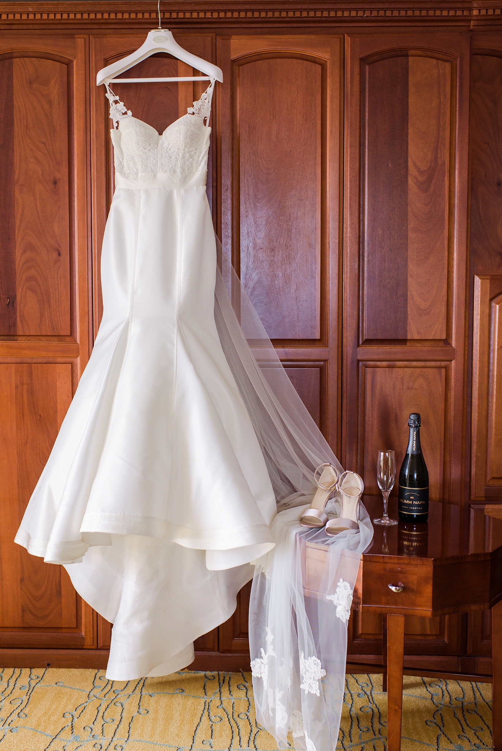 The wedding dress and shoes with champagne accent against a wooden background