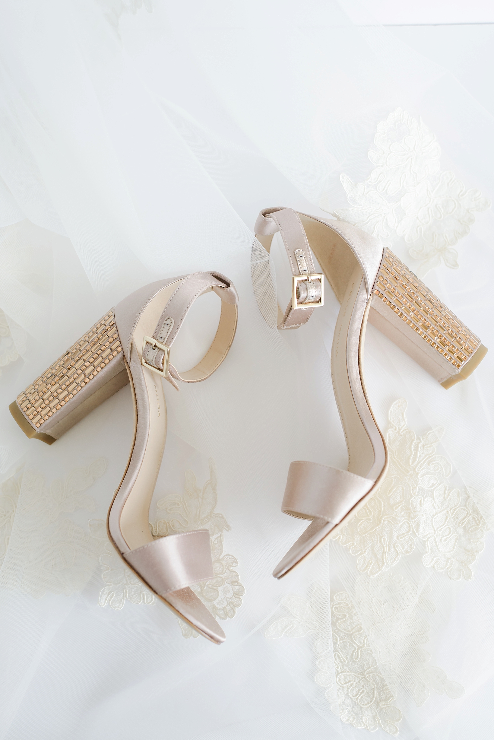 Bride's buckled shoes against the lace detail of her veil