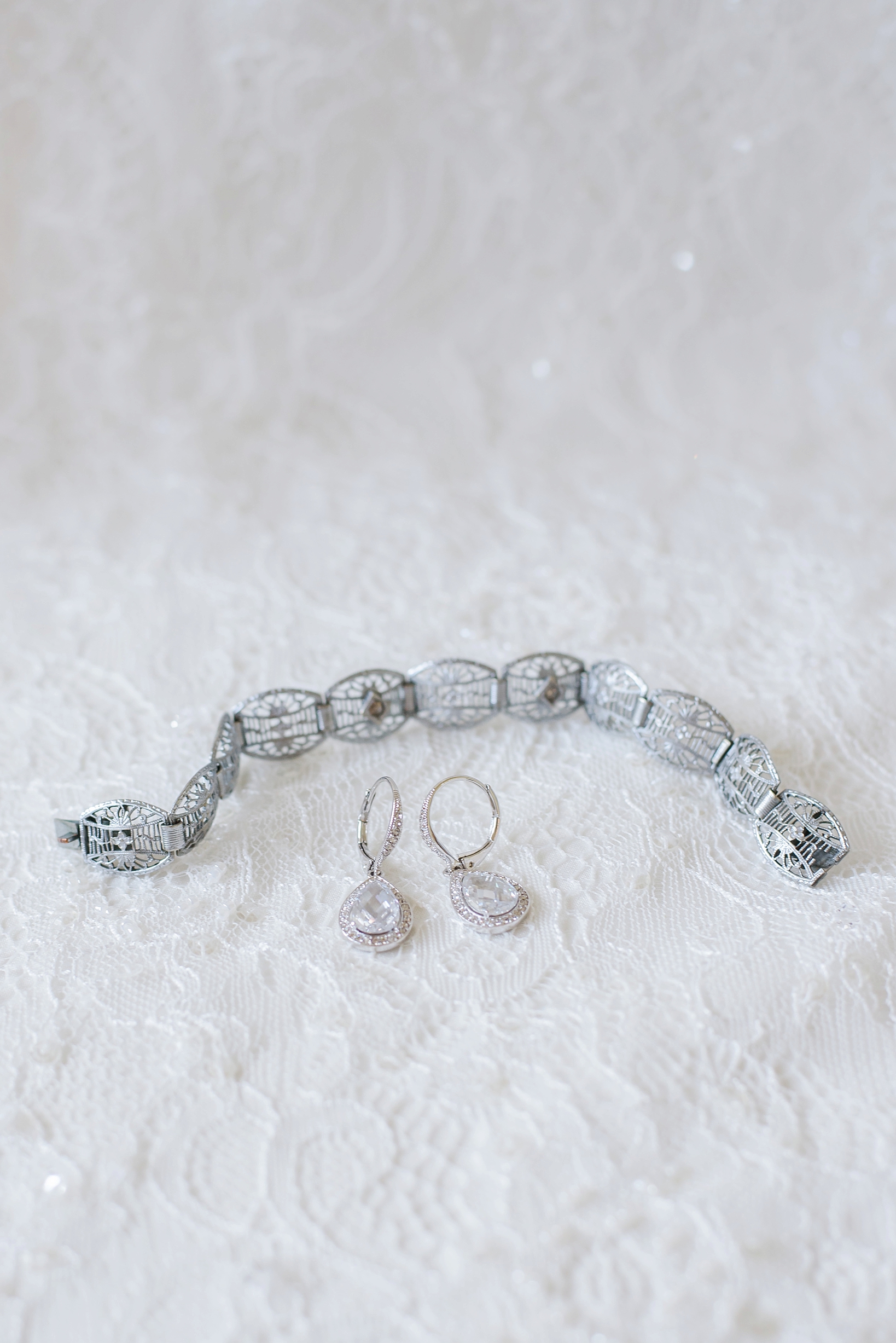 Bride's bracelet and earrings on a lace backdrop