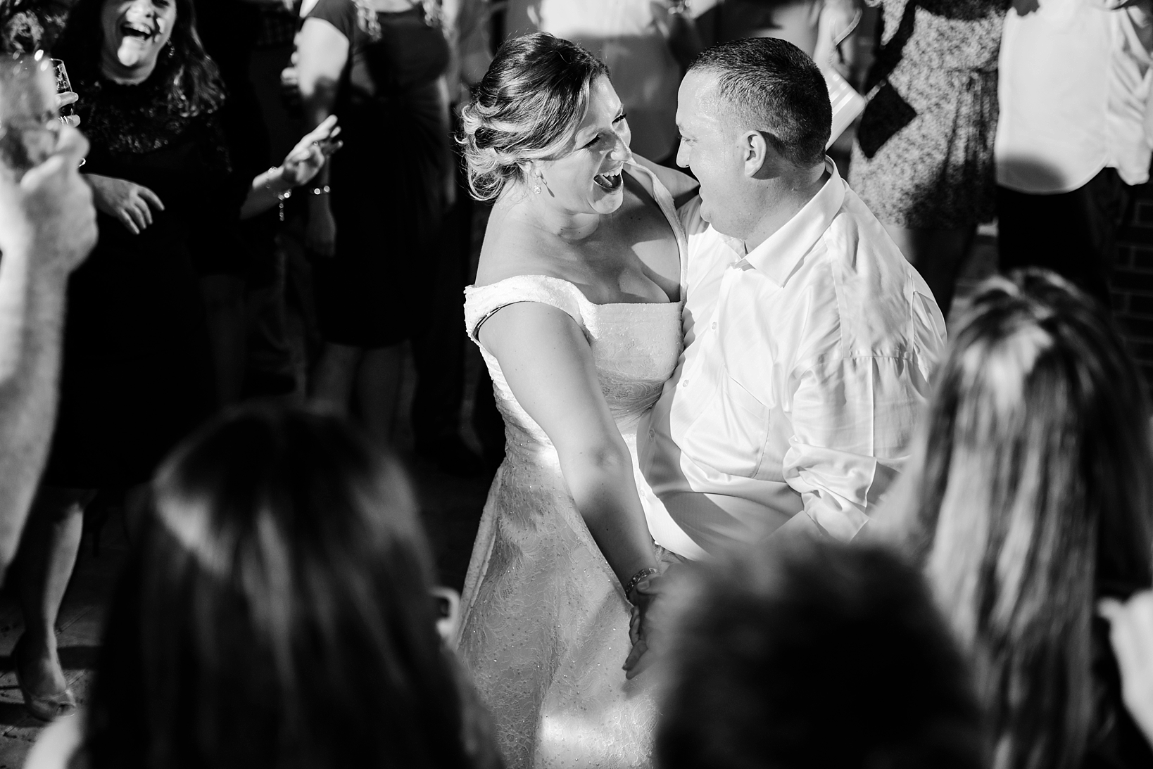 Bride and Groom sharing a joyous moment during their last dance surrounded by all their friends and family