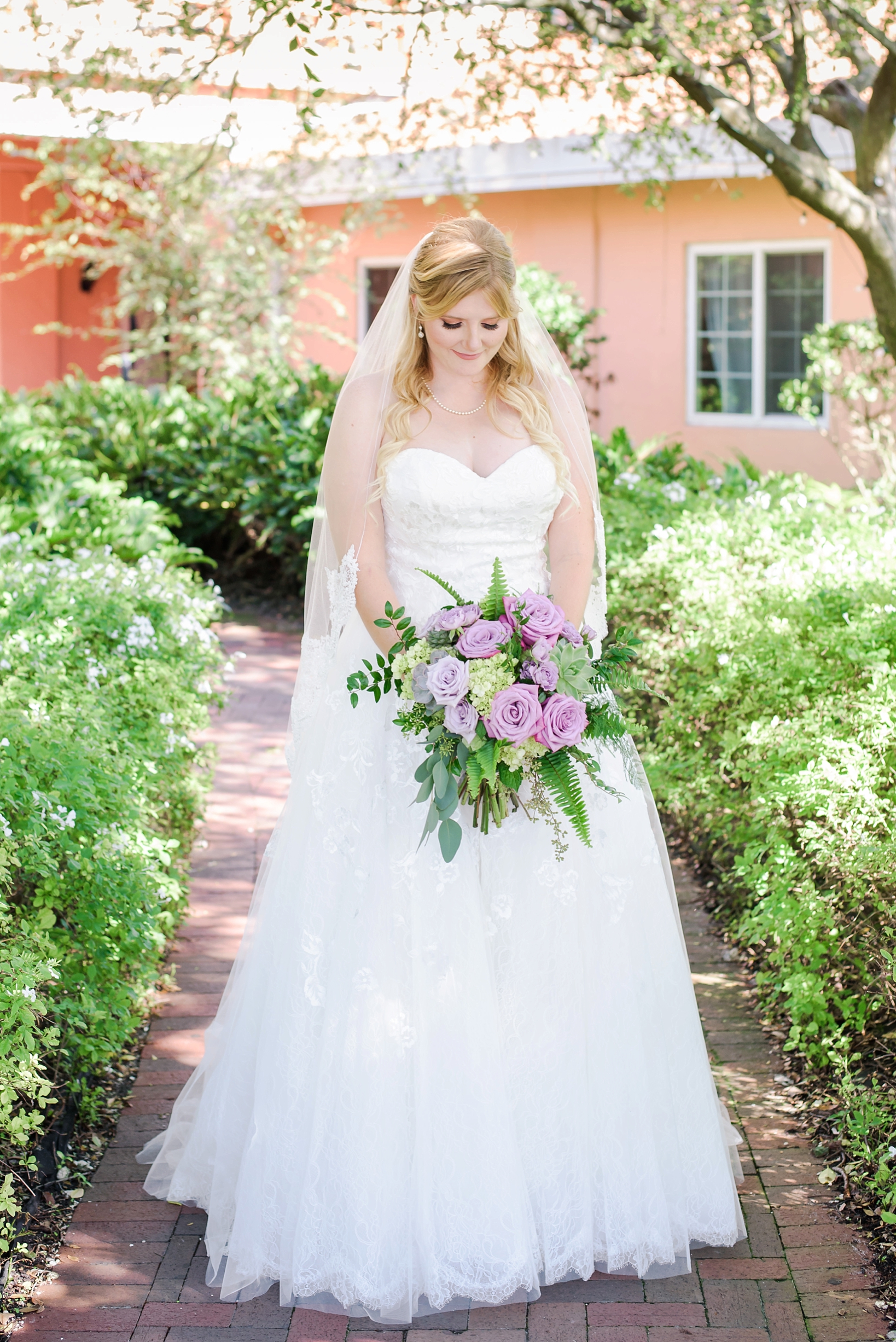 The bride holding her bouquet on a garden path