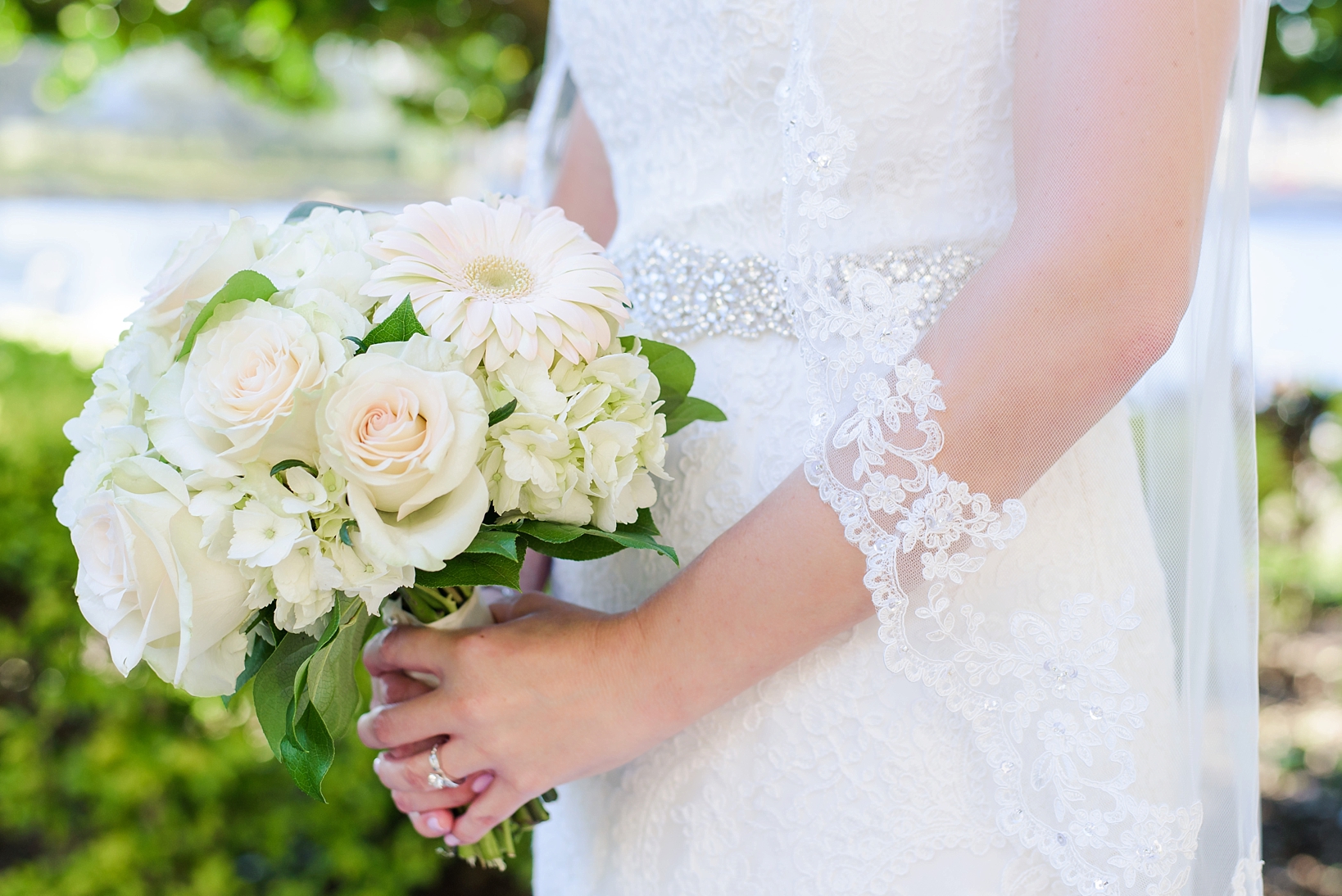 Bridal Bouquet against the Bride's lace gown and veil by Sarah & Ben Photography