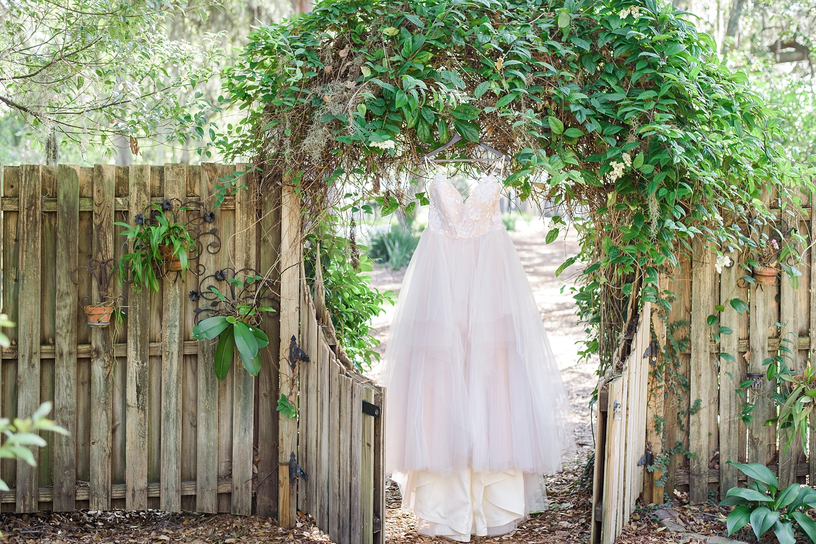 Hayley Paige Wedding Dress hanging on trellis 