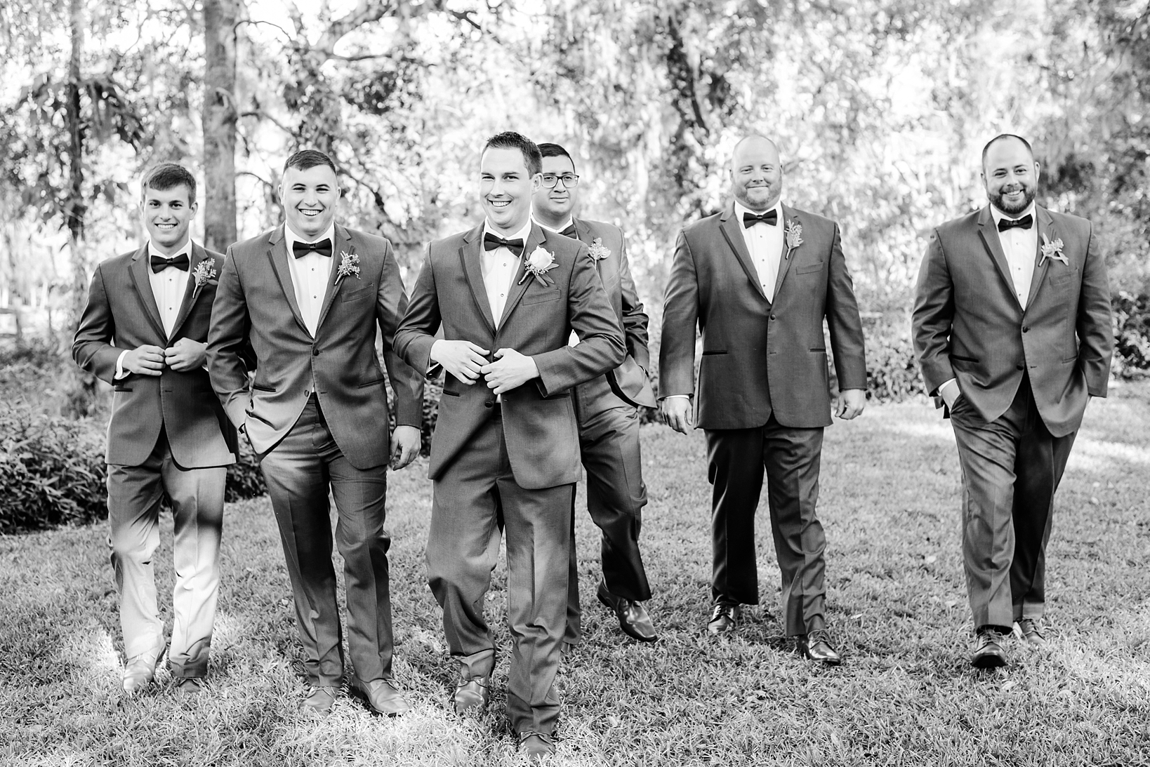Black and White of a Groom and his Groomsmen walking toward the ceremony site