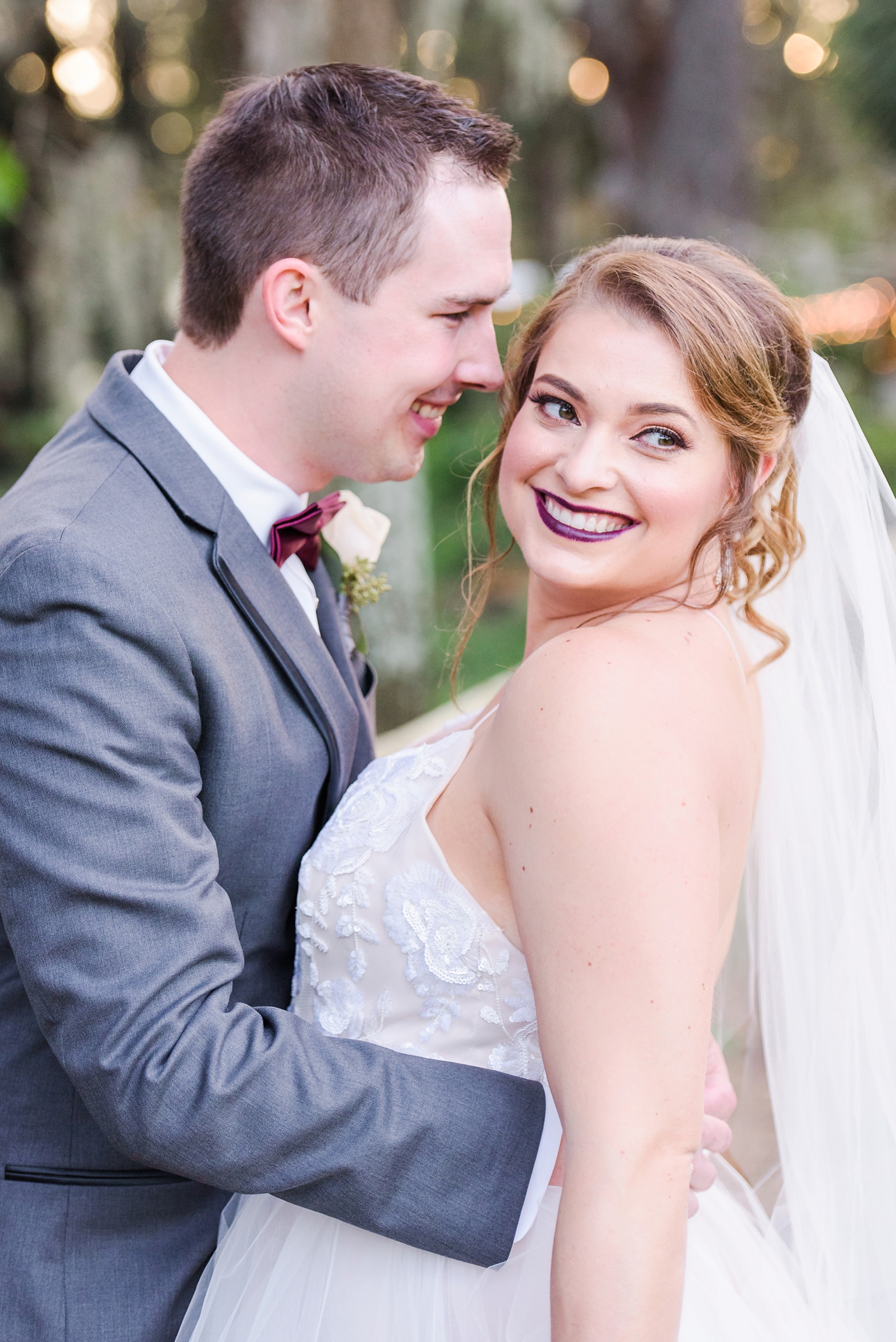 Bokeh fills the background as the Bride and Groom laugh