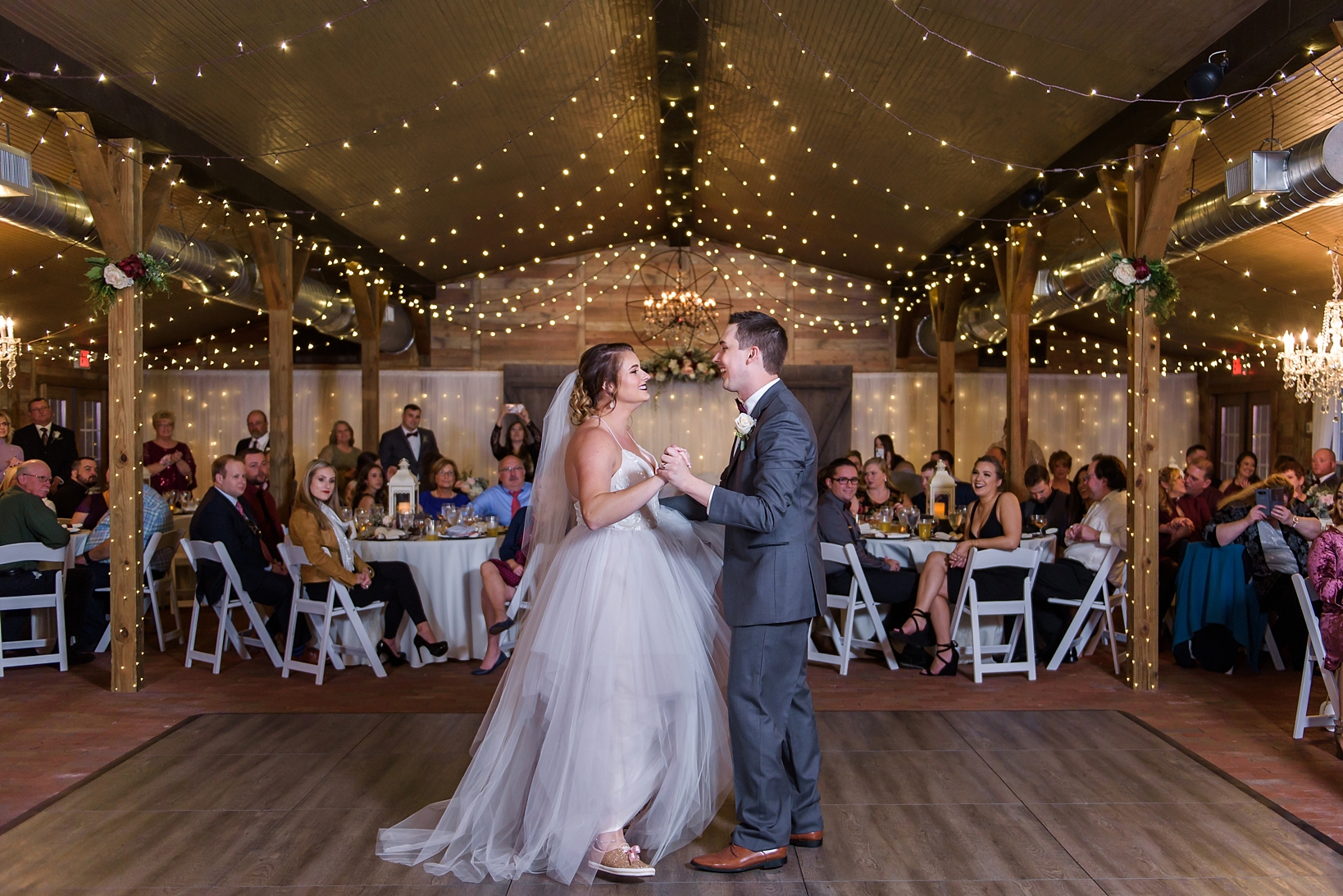 First Dance between Bride and Groom in a rustic barn with string lights