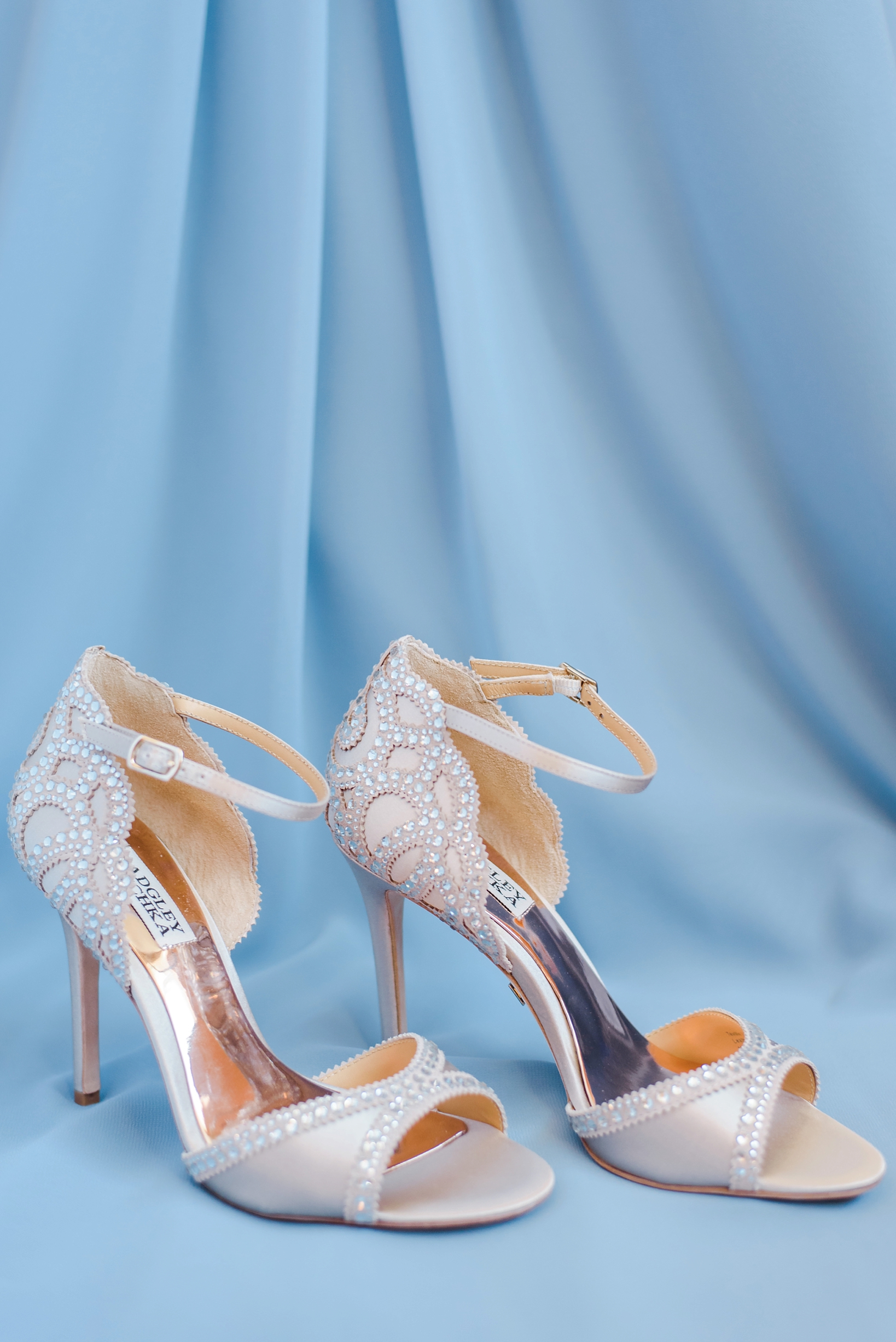Rhinestone strapped bridal heels against the blue of a bridesmaids dress