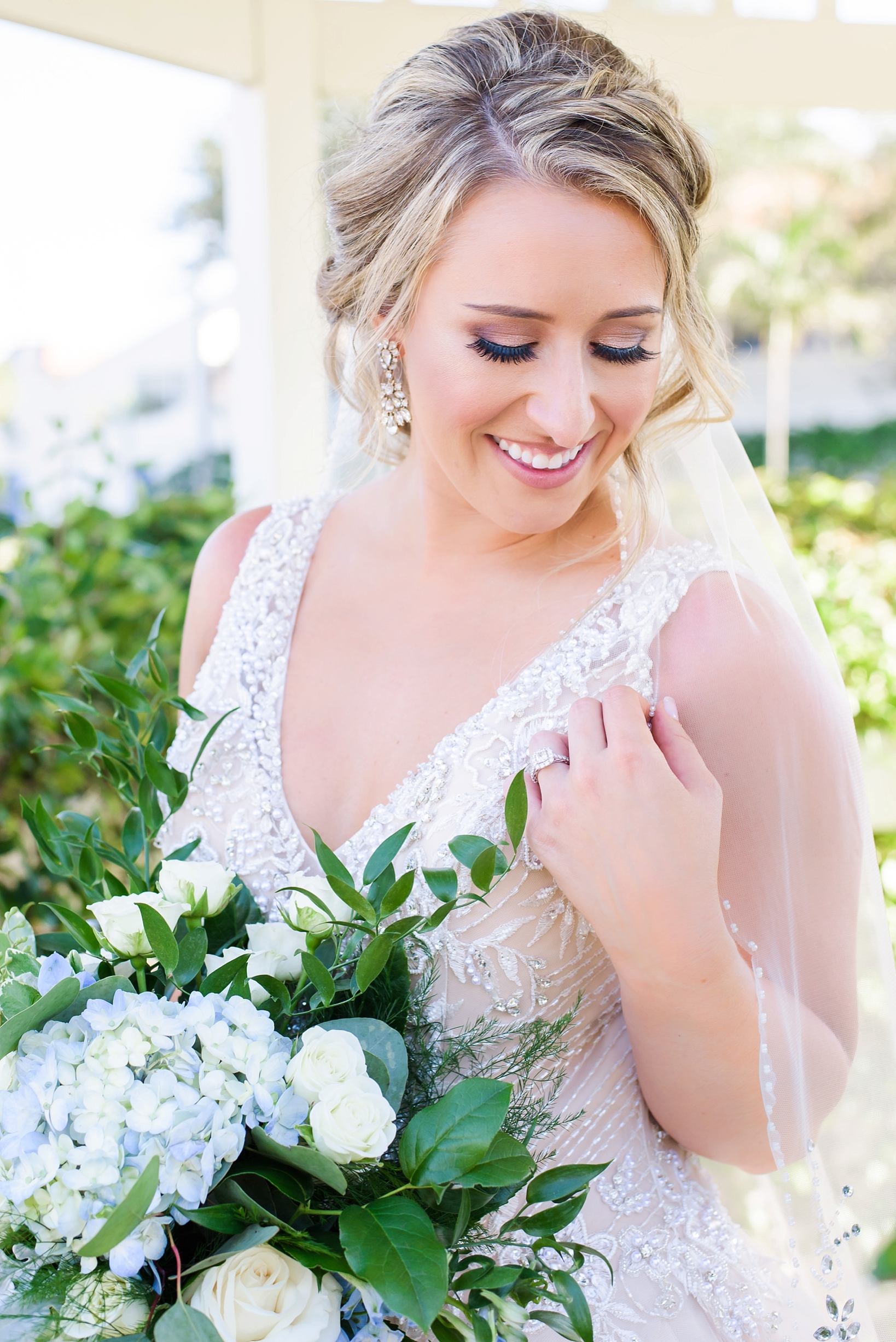 Bride holding her bouquet and veil by Sarah & Ben Photography