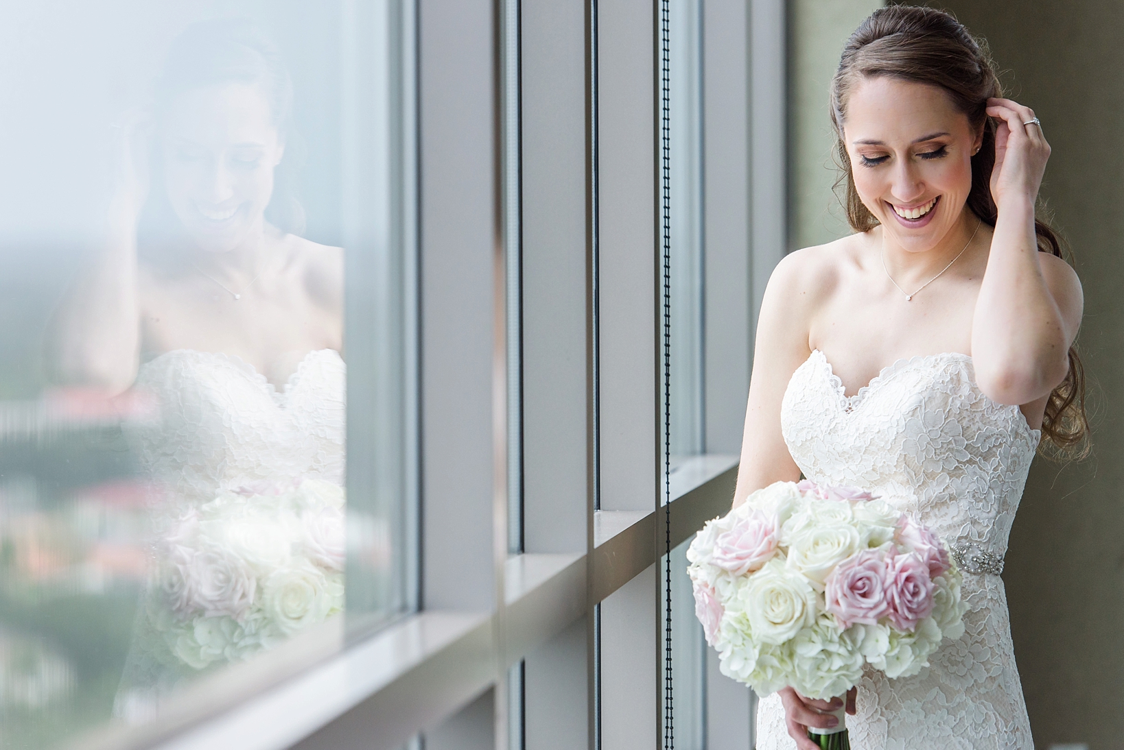 Bride and her reflection in the window holding her bouquet by Sarah & Ben Photography