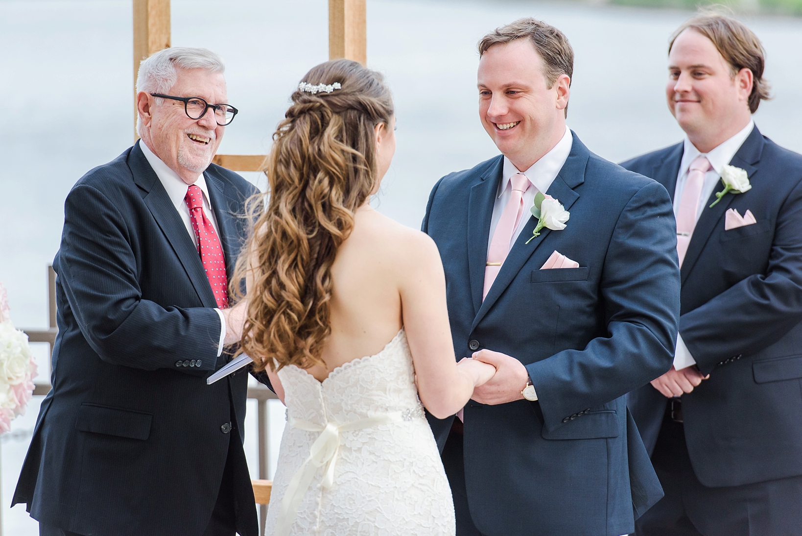 Groom smiling at his Bride during their wedding ceremony by Sarah & Ben Photography