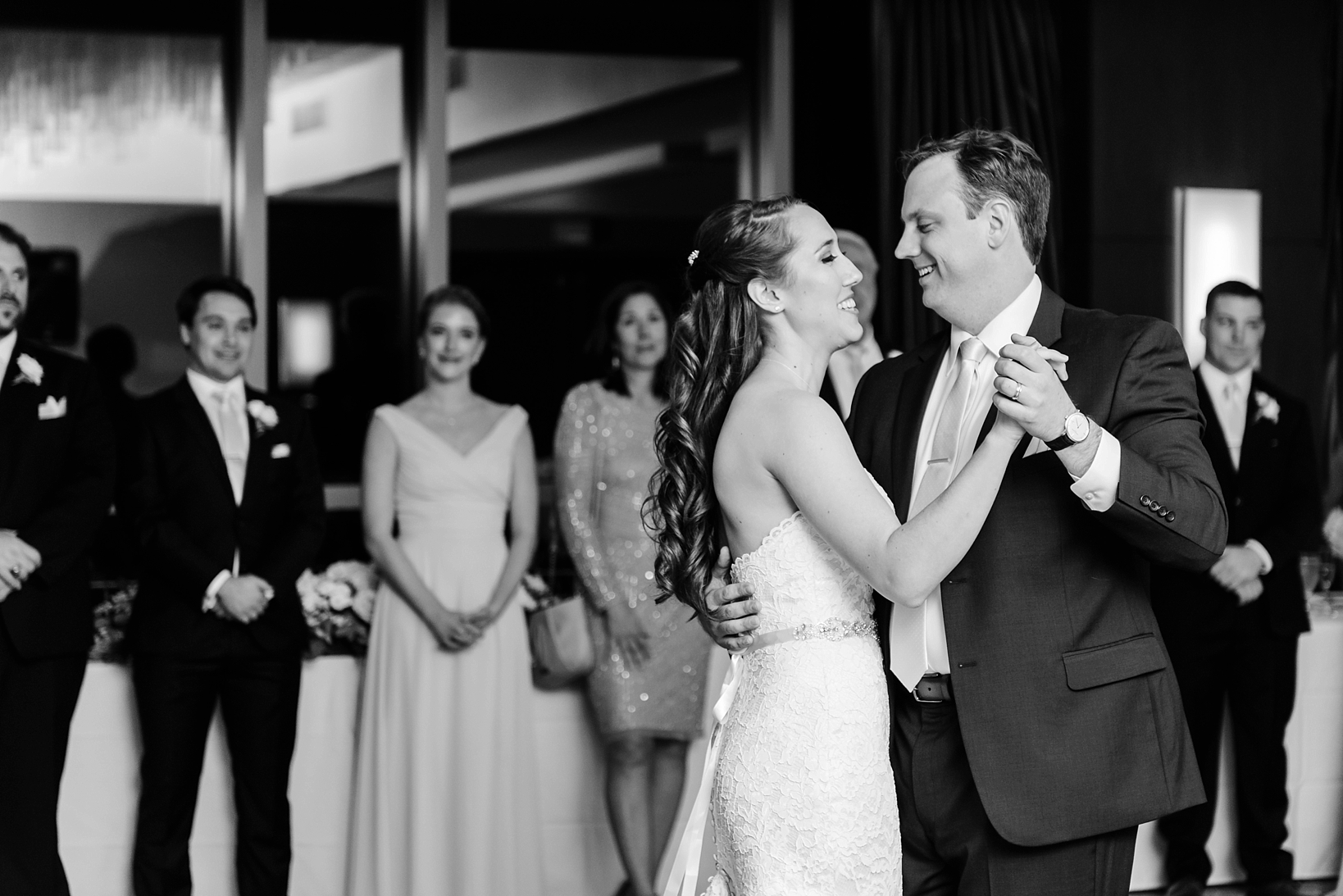 Black and White picture of the Bride and Groom dancing as the bridal party watches in the background