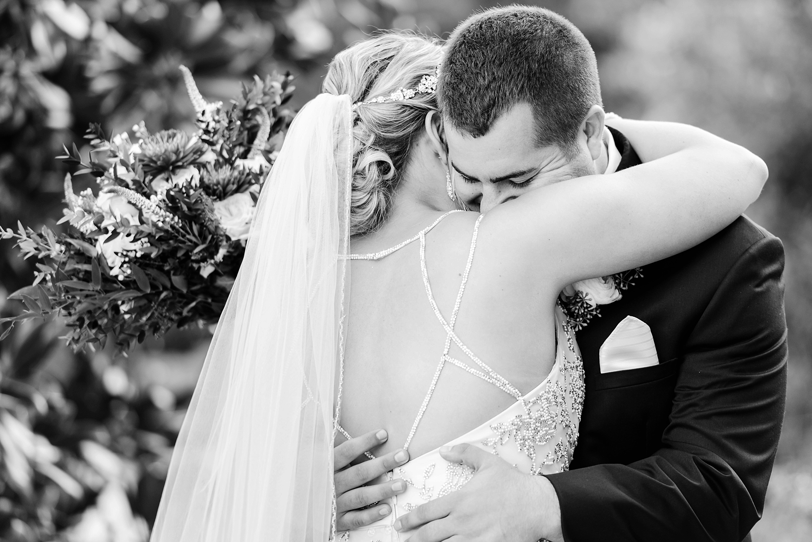Black and White image of a bride and groom hugging on their wedding day