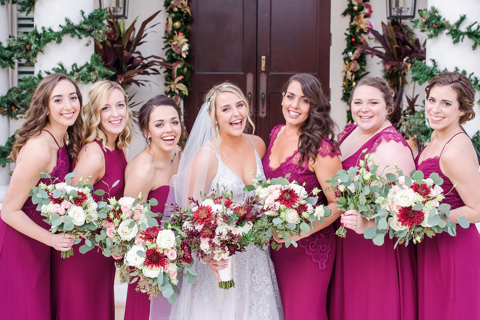 Bride and Her Bridesmaids holding floral bouquets in front of the wedding ceremony