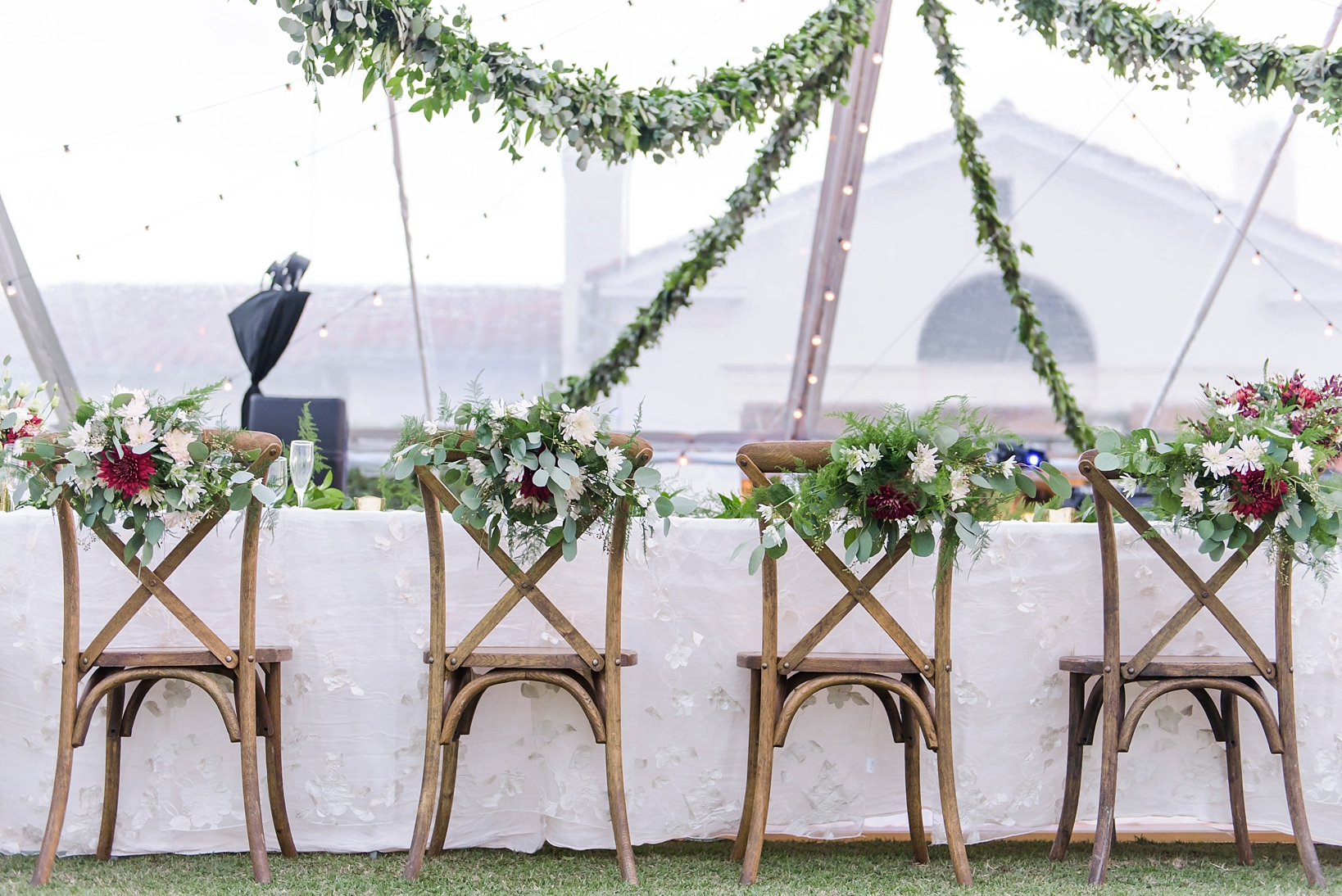 Floral decorated rustic chairs during a tented reception